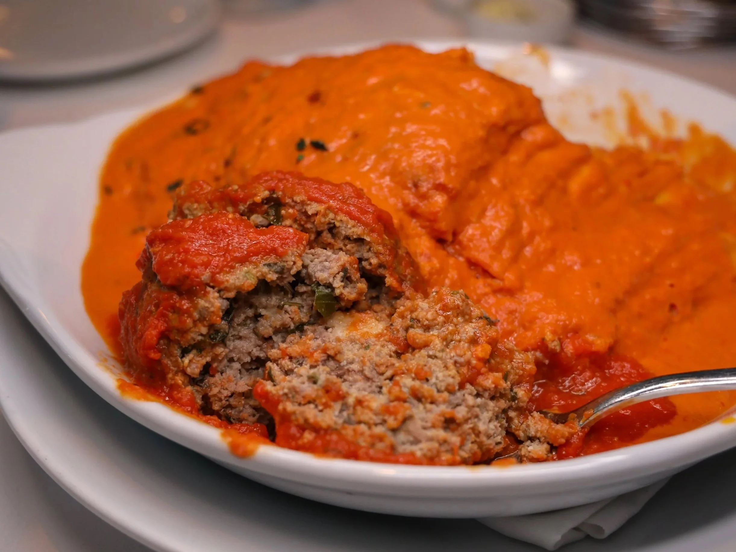 A close-up cross-section of the Wagyu beef and ricotta meatball added to the Lasagna alla Vodka at Ristorante Paoletti.
