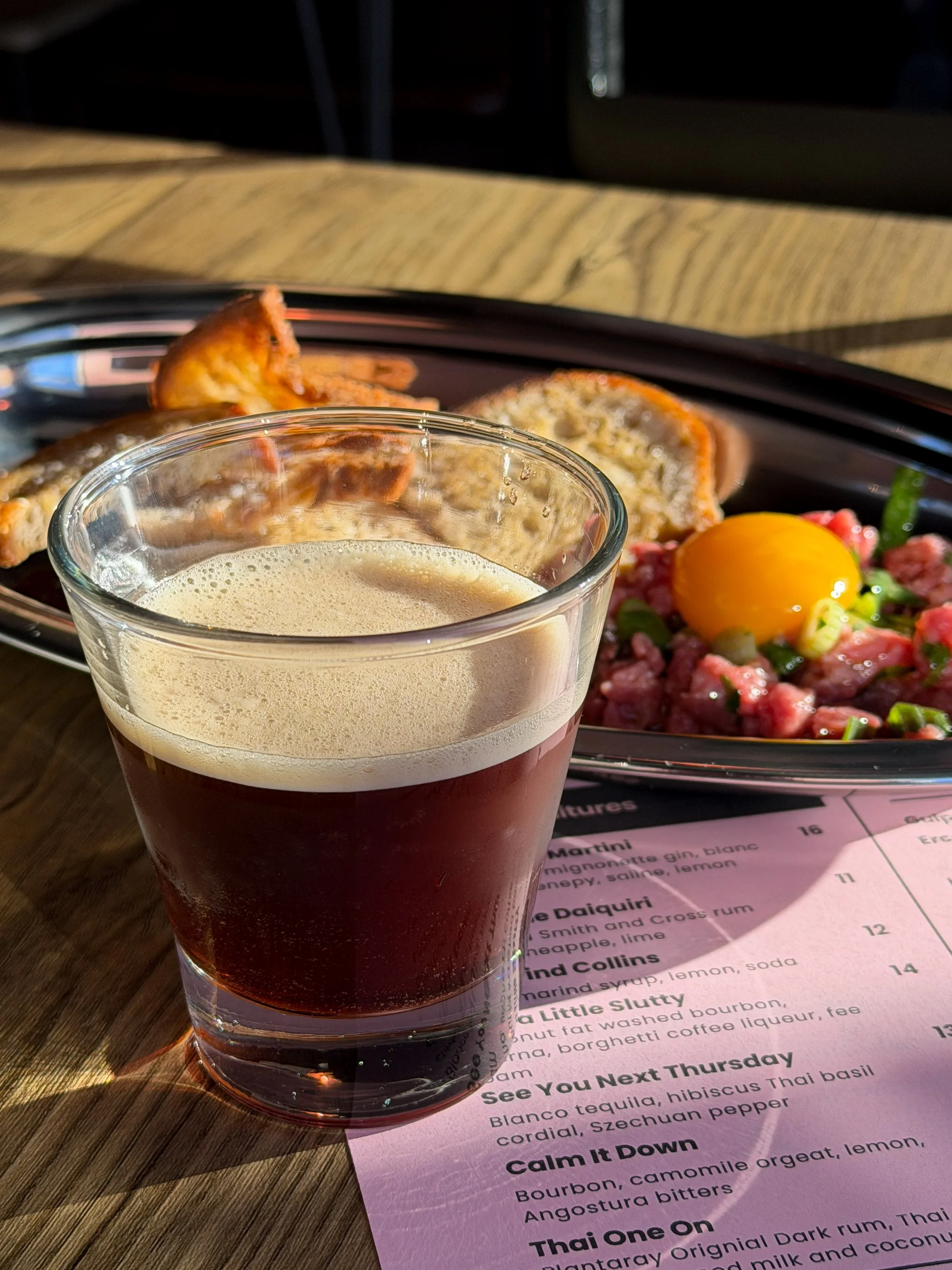 Just a Little Slutty espresso martini next to beef tartare at Little Secret in Greenville, SC