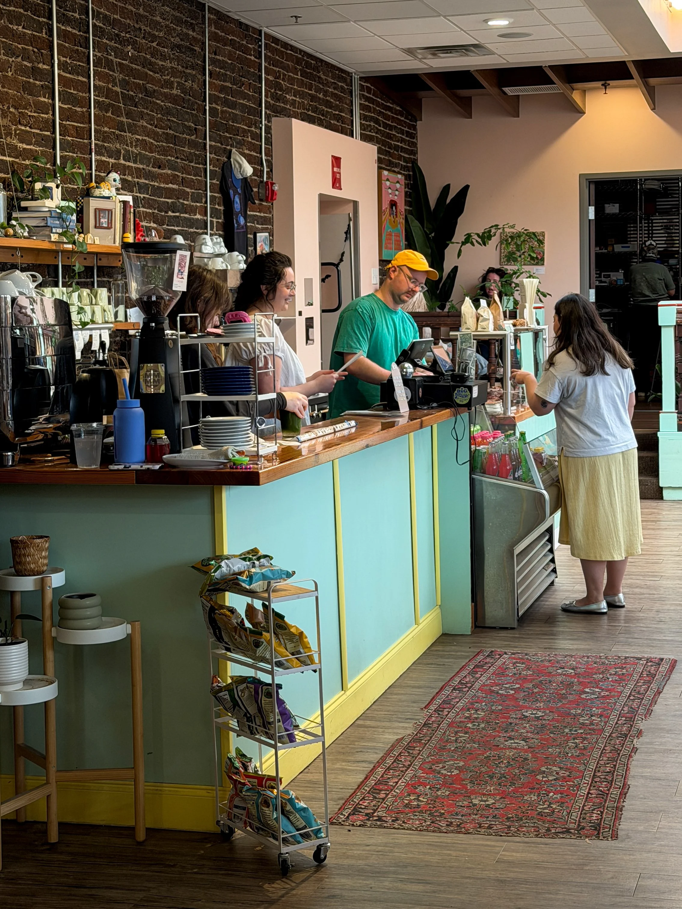 The counter service area at Potchke Deli in Knoxville, with staff ringing up a customer's order at the register