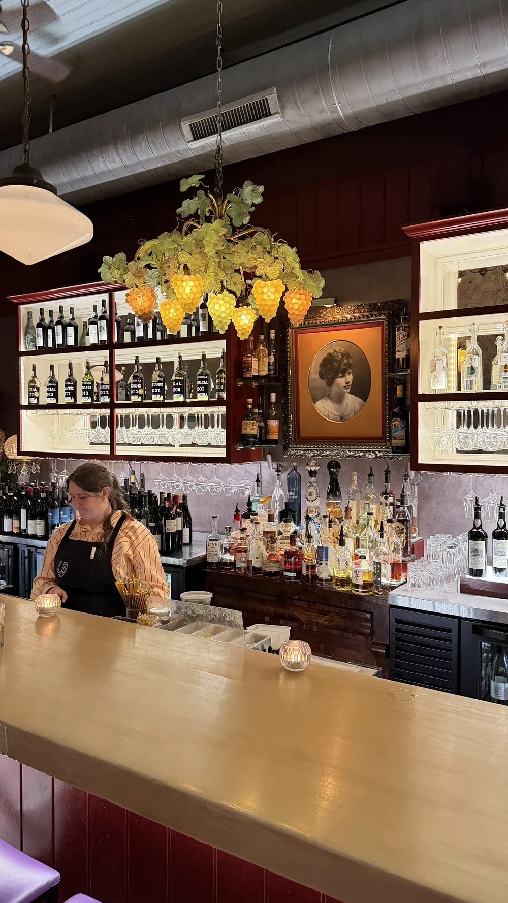 Bar area with grapevine chandelier and Lula Drake's portrait at Lula Drake Wine Parlour