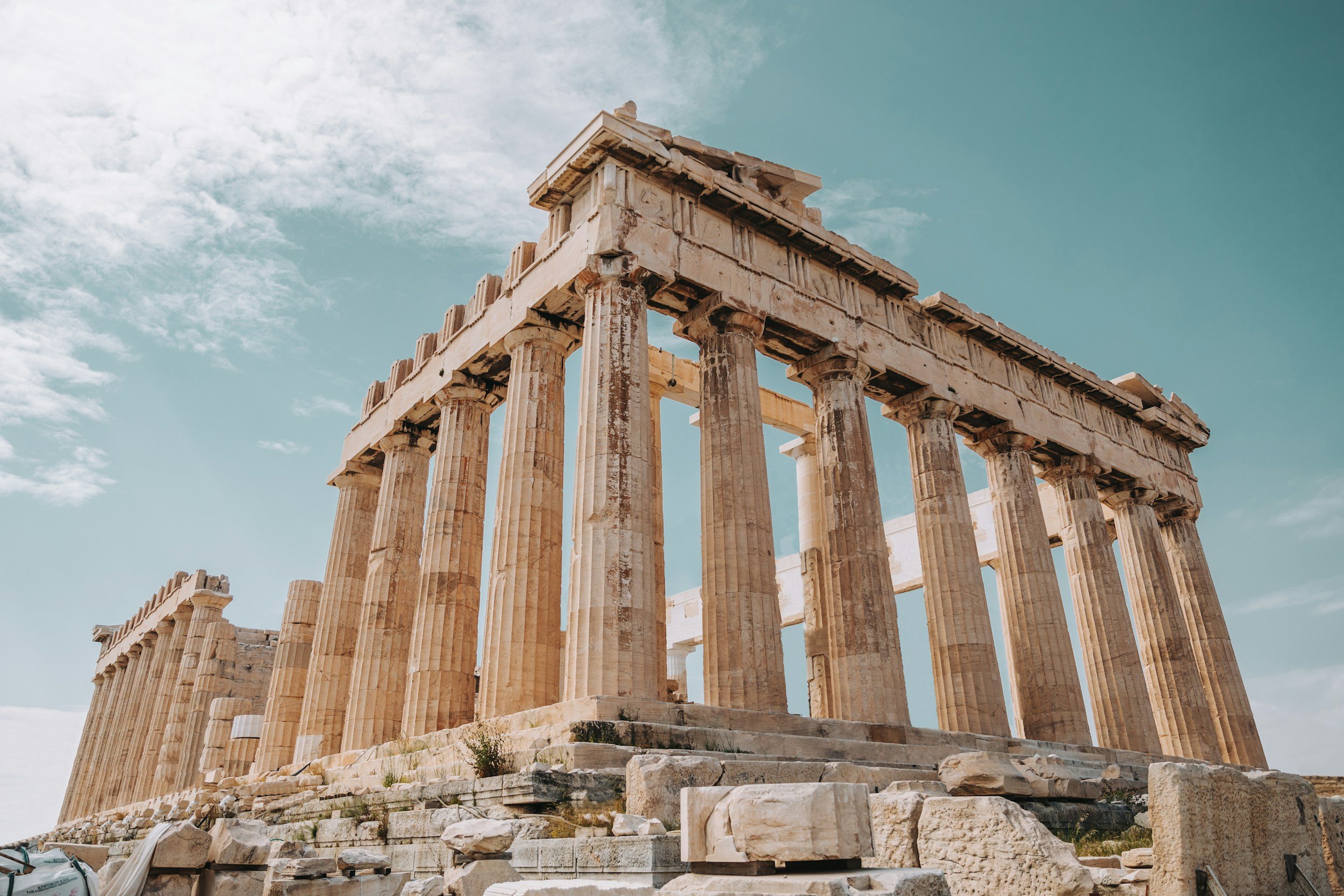Ancient Greek Parthenon temple with classical columns on a partly cloudy sky