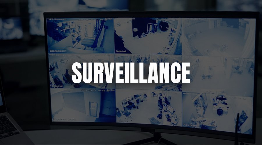 A security monitoring screen displaying multiple surveillance camera feeds with the word "SURVEILLANCE" written across the center.