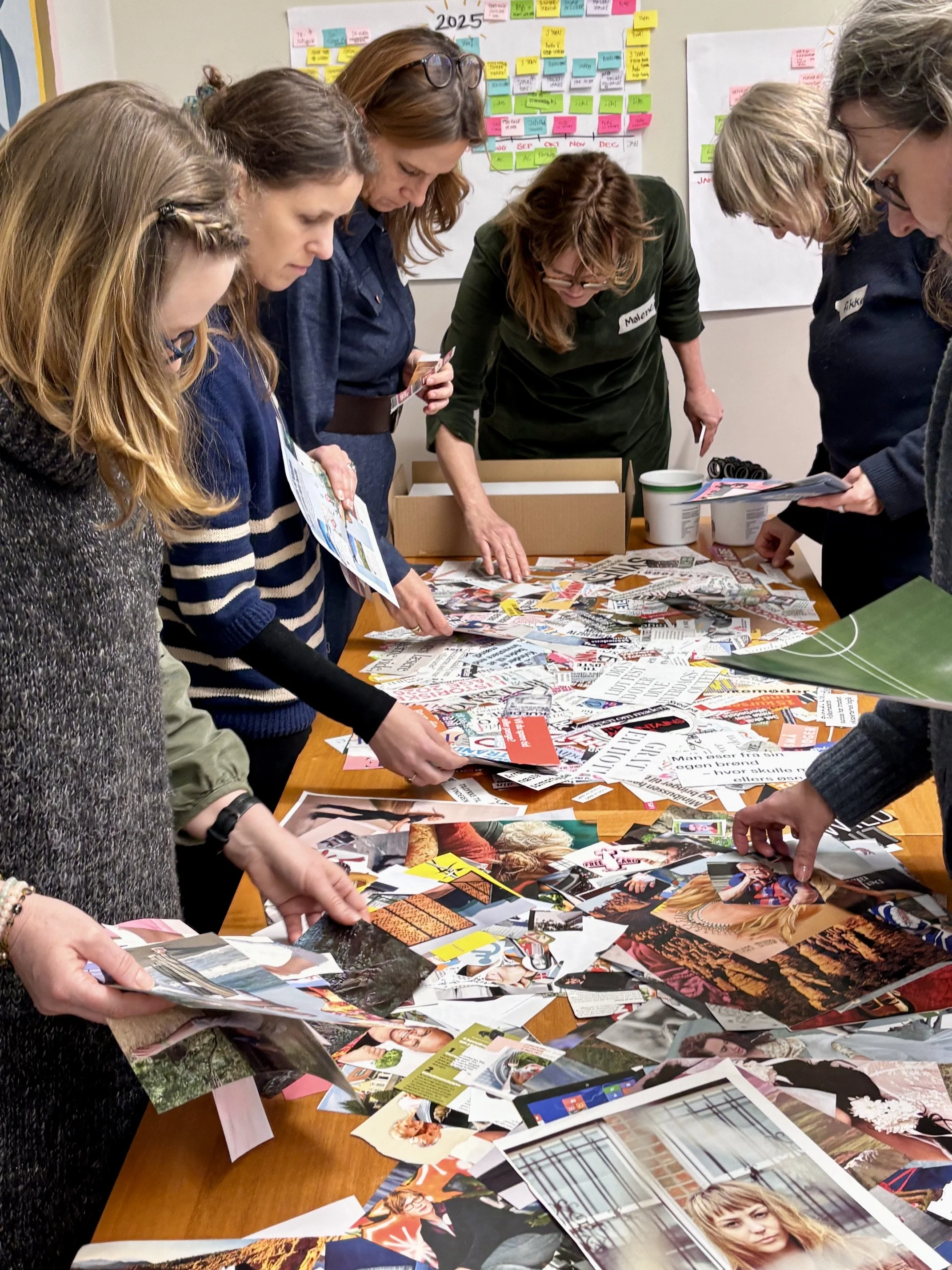 Deltagere på en workshop arbejder med udklip, som bliver til deres collage for det kommende år