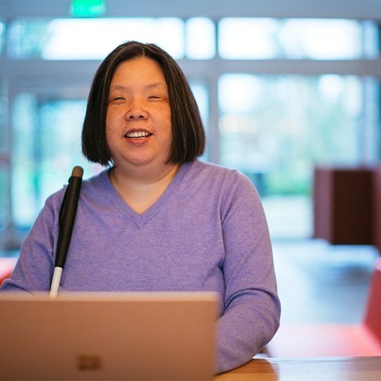 Blind asian woman on a podium giving a speech