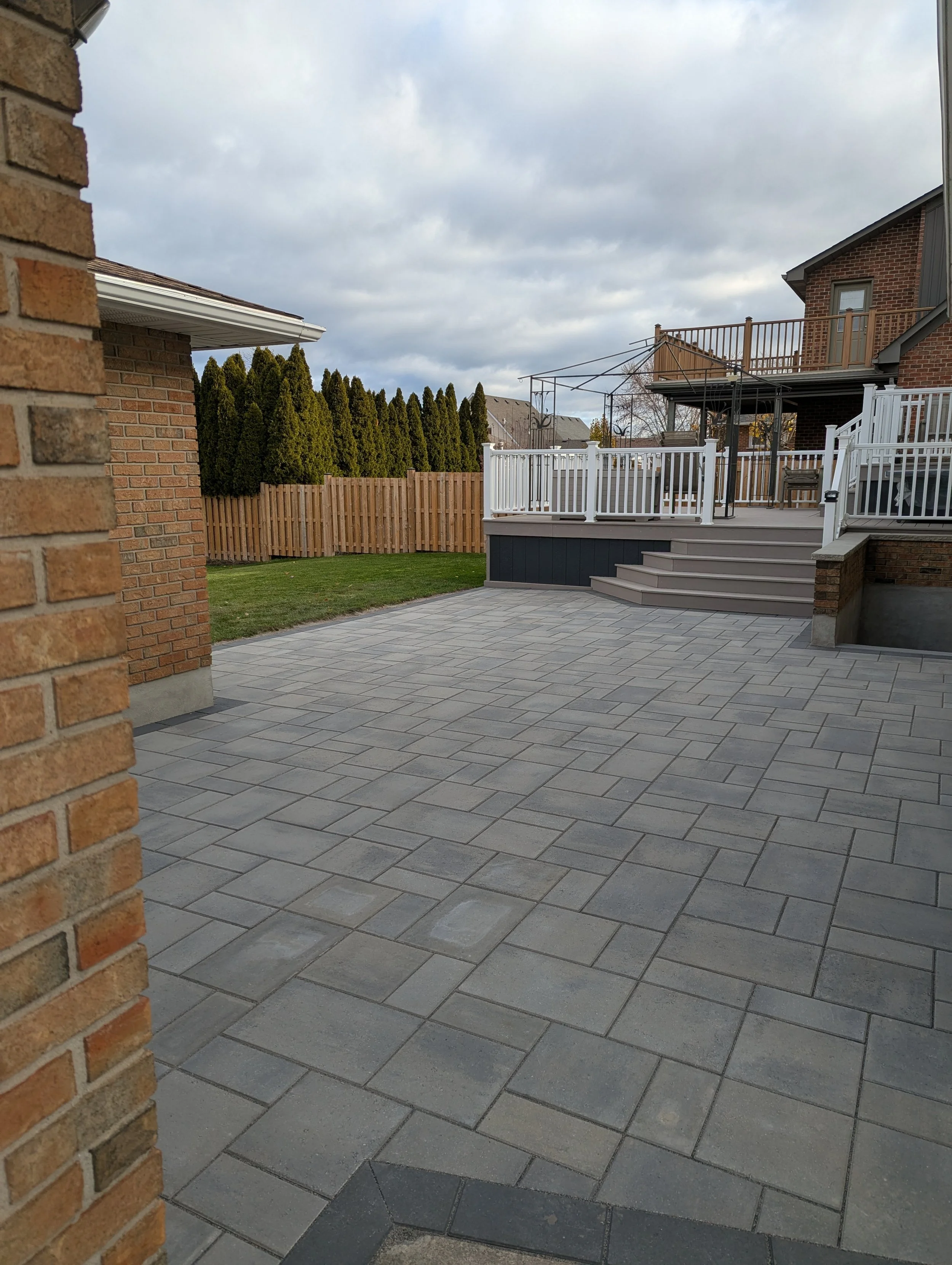 Wide view of a professional stone paver patio installation featuring Techo-Bloc Blu 60 pavers.