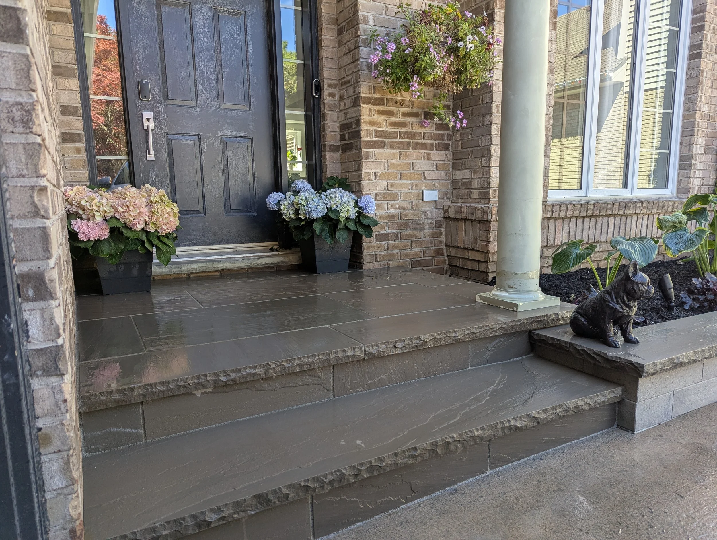 A modern front entrance featuring Oakville Stone's Slate Grey square cut flagstone and stair treads