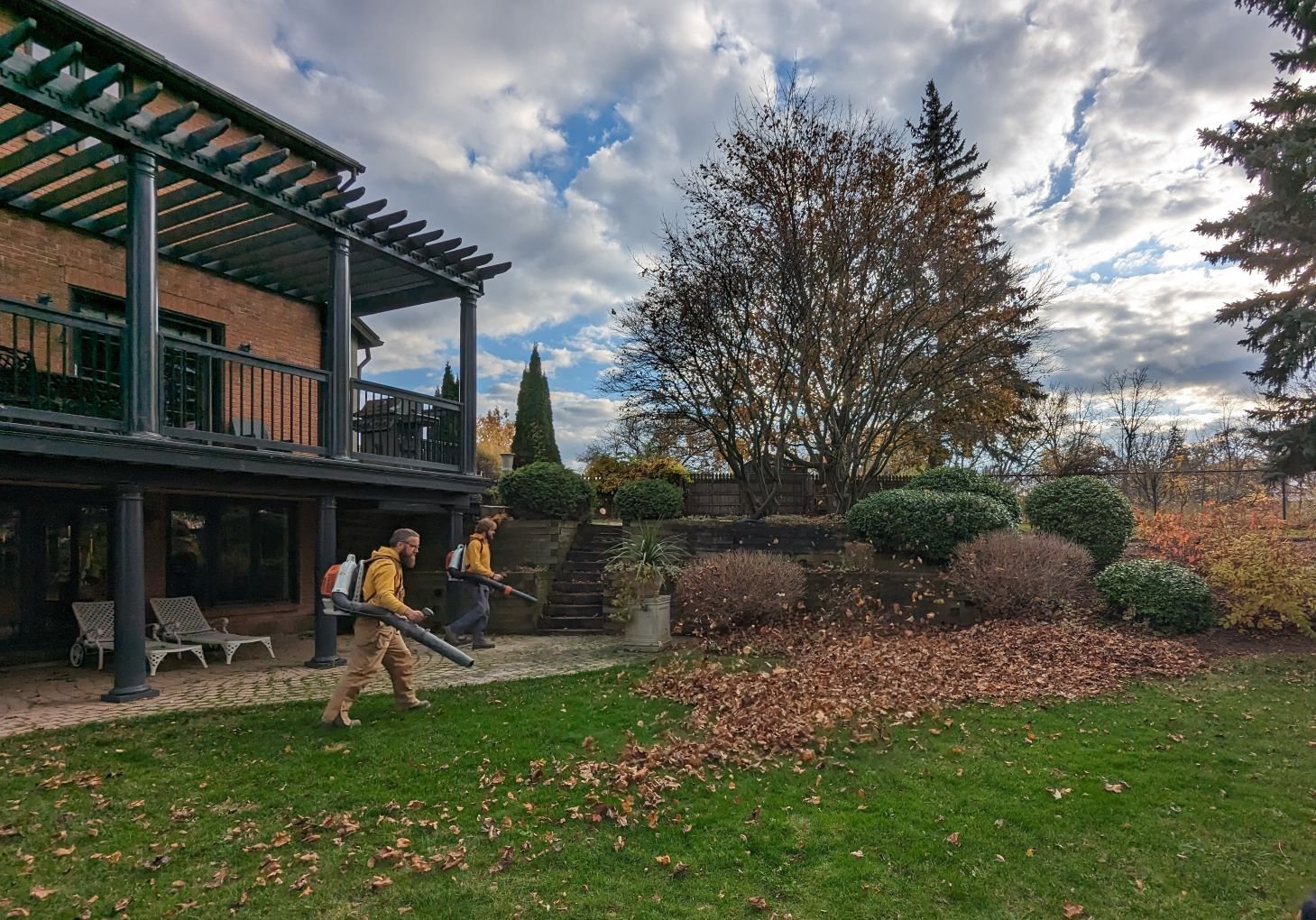 Gardenstone Landscaping crew clearing a residential lawn in St. Catharines using leaf blowers for a thorough fall seasonal cleanup.