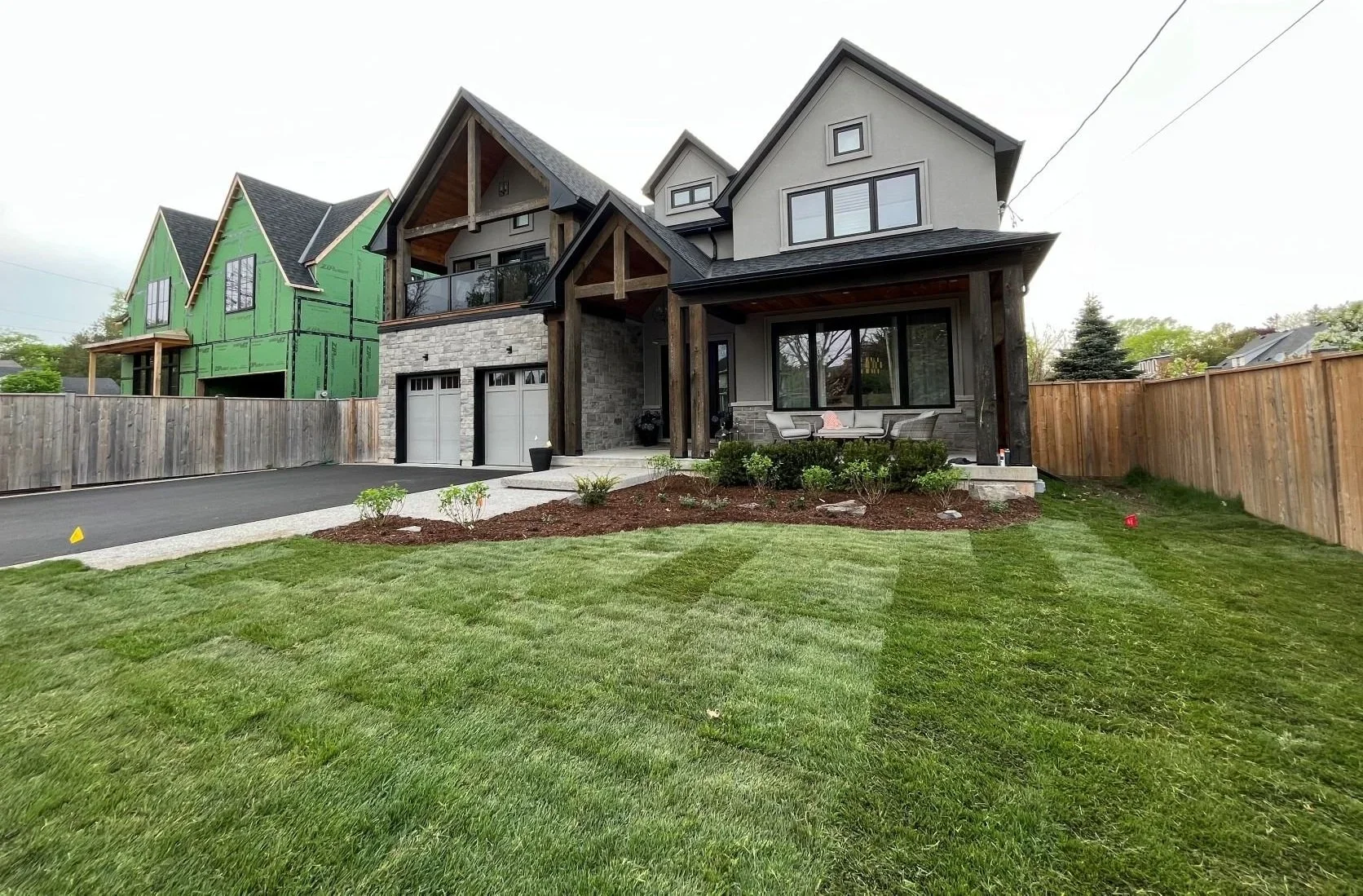 Complete front yard landscaping in St. Catharines featuring freshly installed premium sod and mulched garden beds for a modern home.