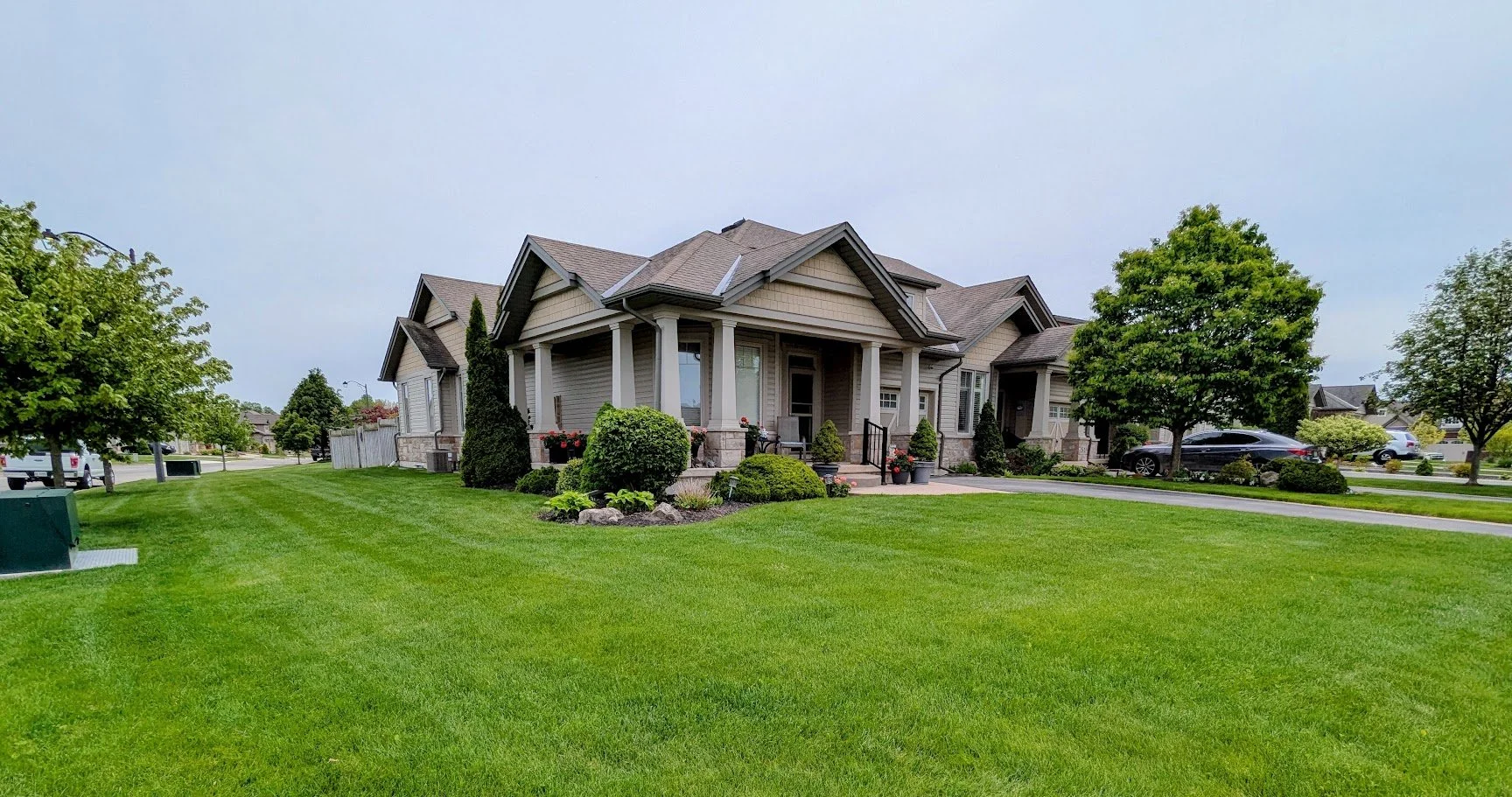Freshly mowed lawn with striping and clean sidewalk edging, showcasing a professional weekly lawn care transformation.