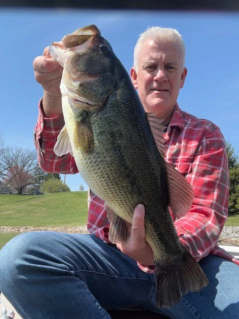 Angler holding a 6-pound largemouth bass caught in Indianapolis, showing the size and detail of the trophy fish.