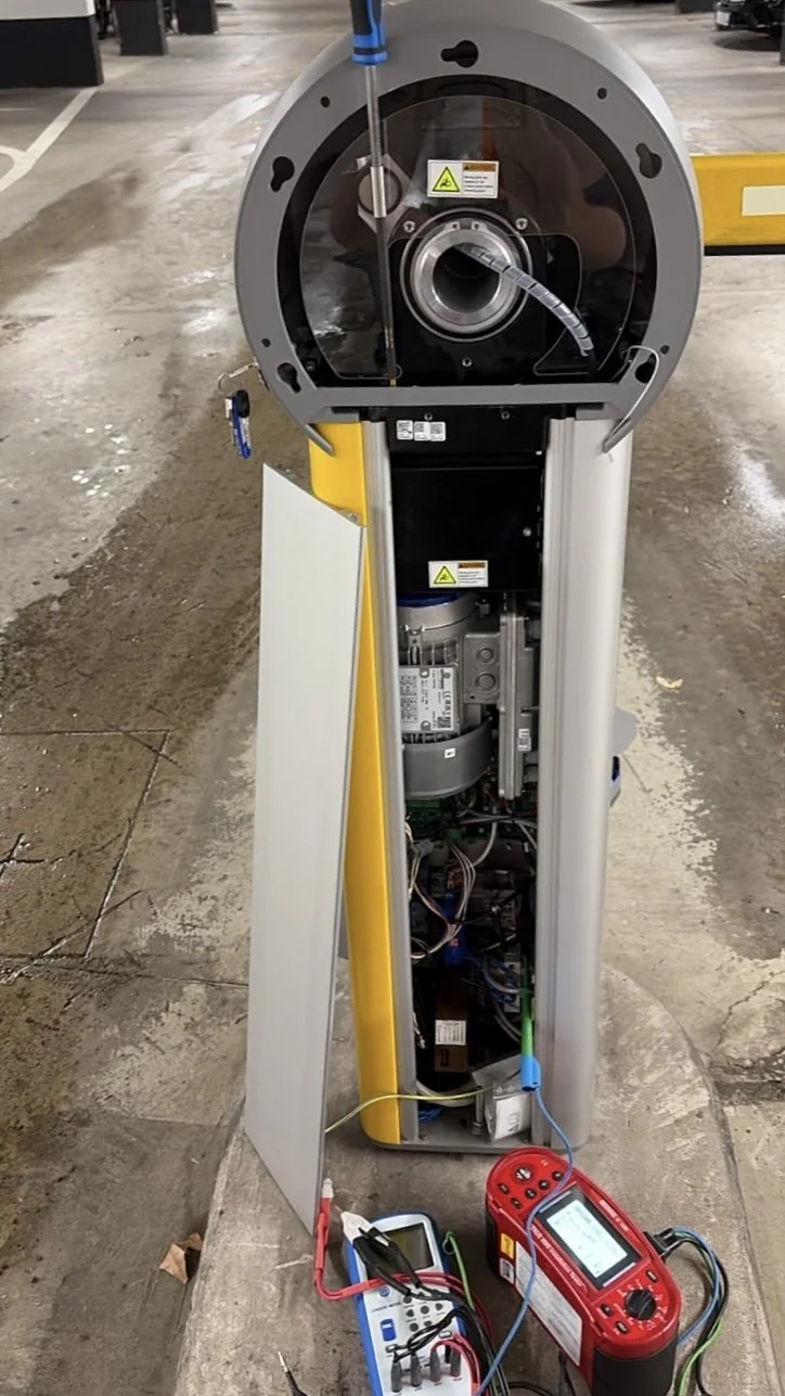 Aufnahme eines aufgebrochenen Fahrkartenautomaten in einer Tiefgarage, das Gehäuse ist geöffnet, technische Komponenten und Verkabelung sind sichtbar, Werkzeuge und Messgeräte liegen davor.
