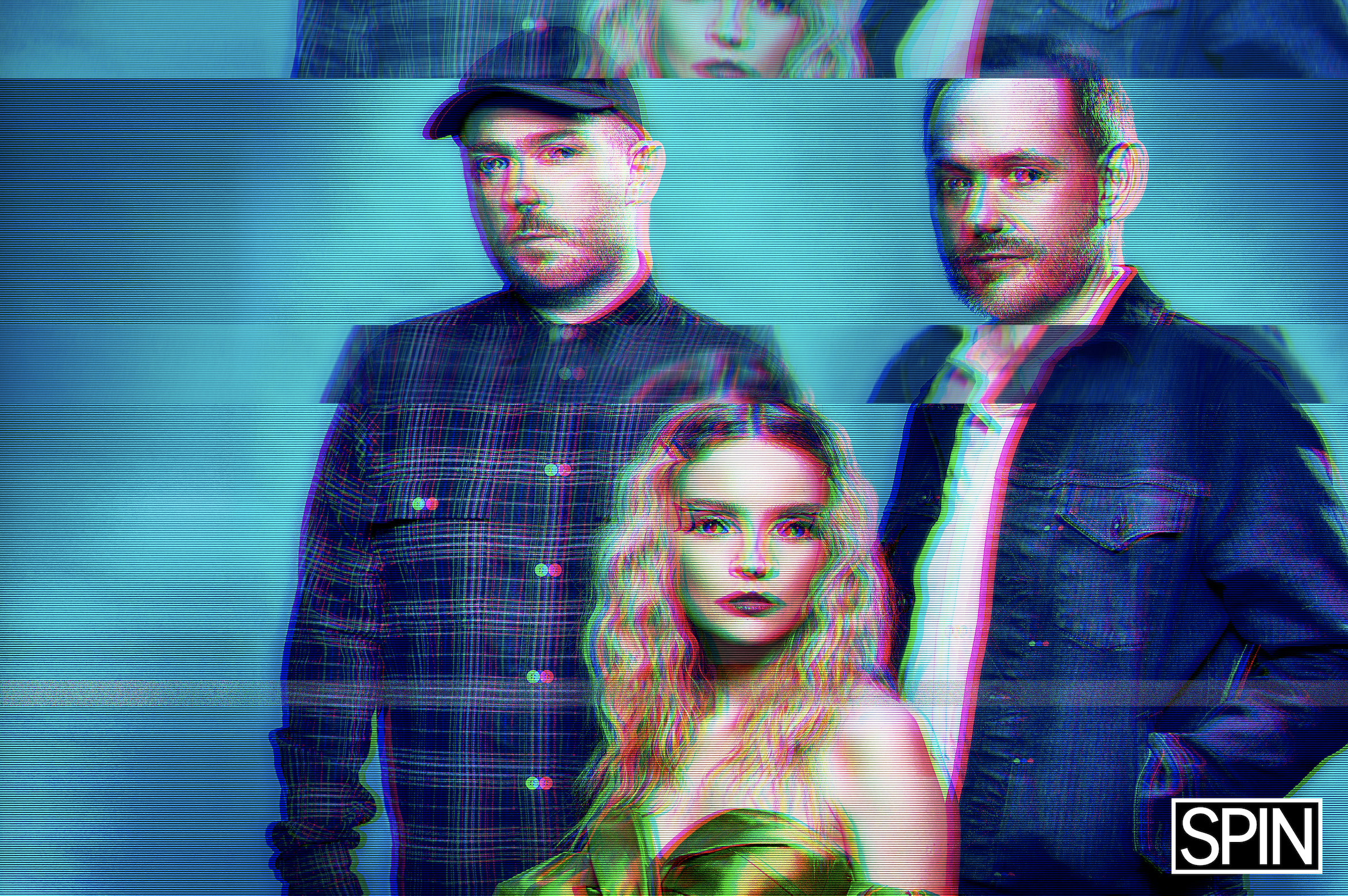 Three people posing for a photo with glitch effects. Two men standing behind a woman who is sitting, all looking at the camera. The woman has curly blonde hair and bold makeup. The logo 'SPIN' is in the bottom right corner.