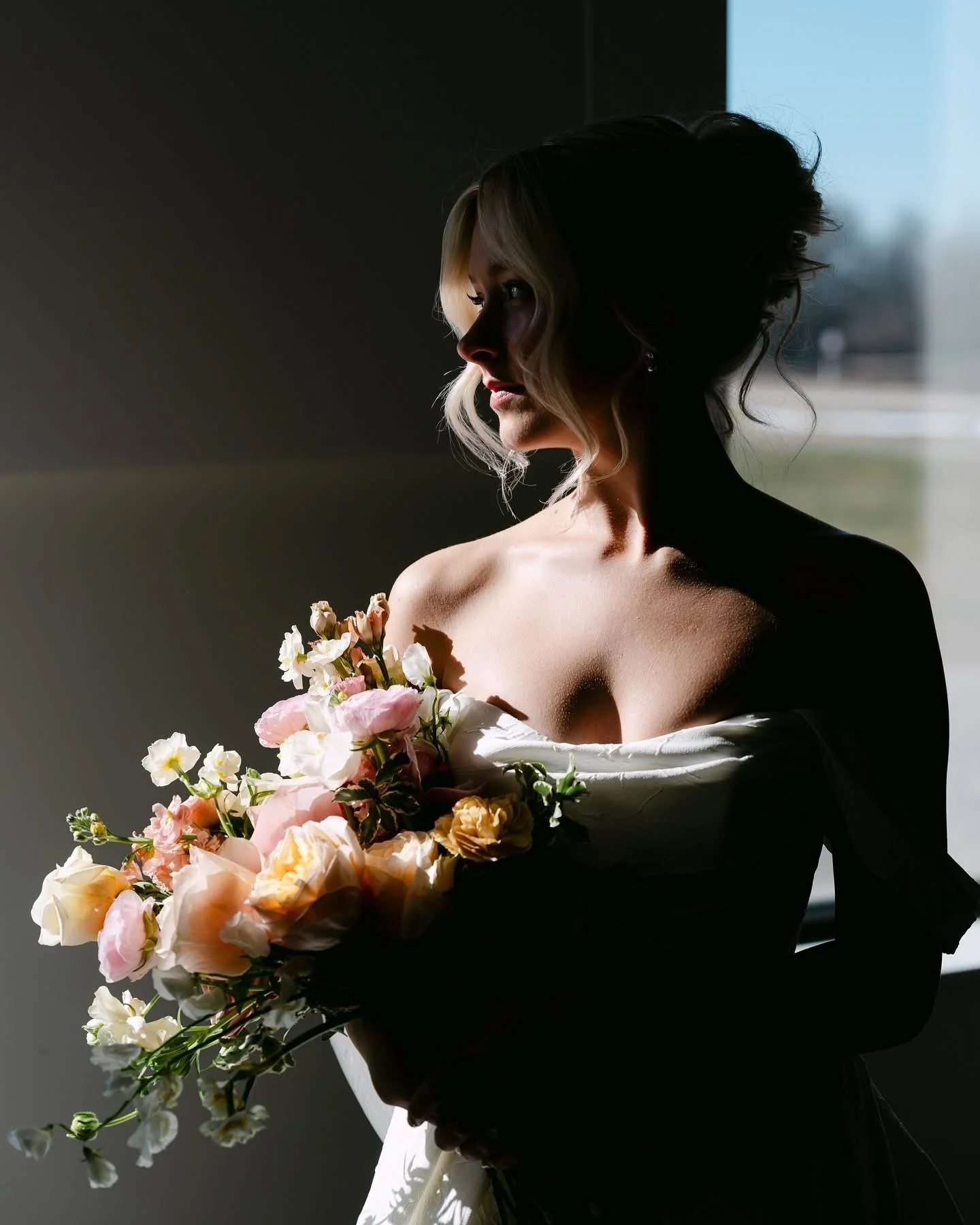 Bride gazes out a window at her wedding in Grand Haven, MI photographed by Tonya Hjort Photography
