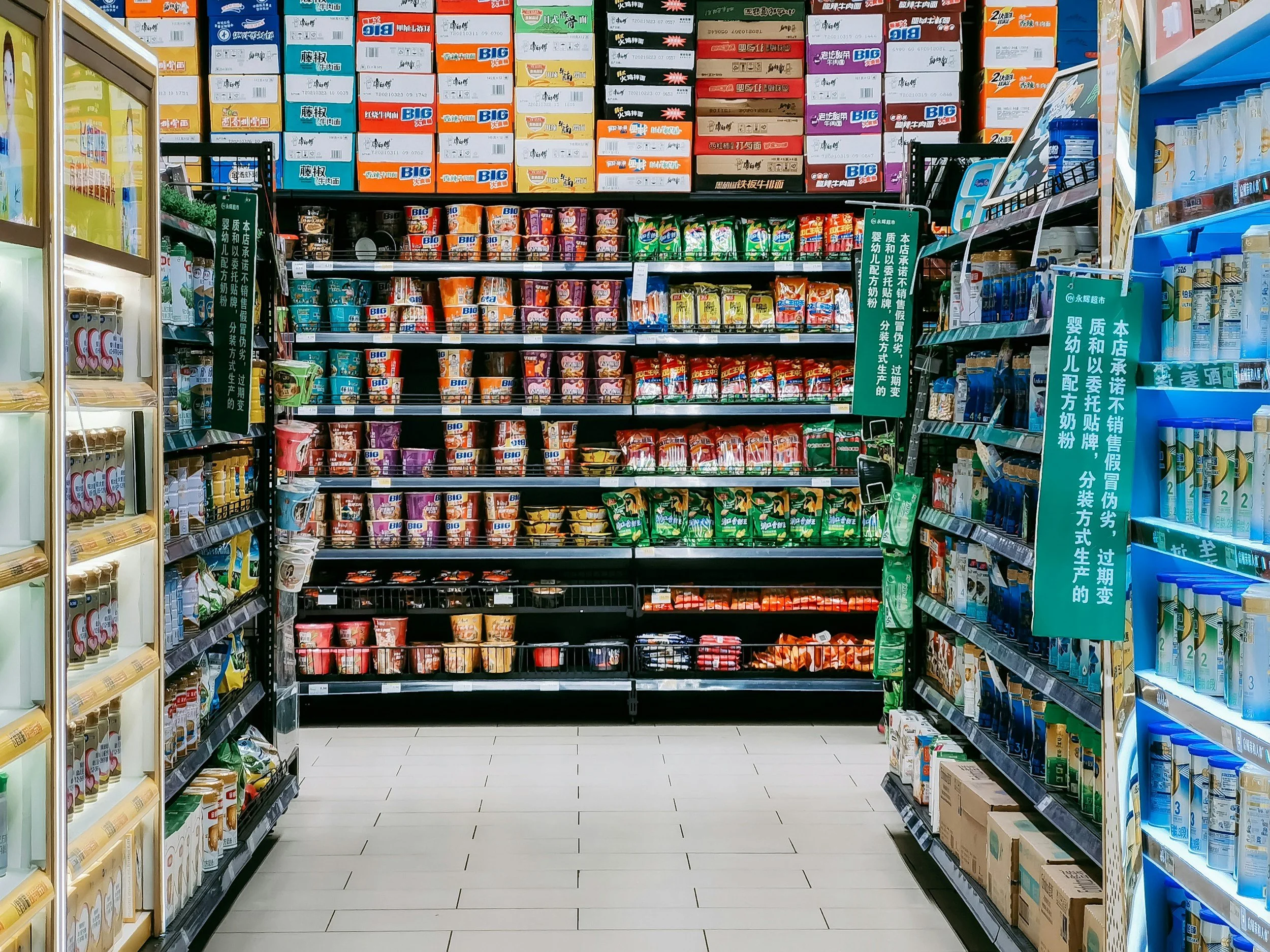 View of supermarket aisle with shelves stocked with various cartons and packages of milk, yogurt, and dairy products.