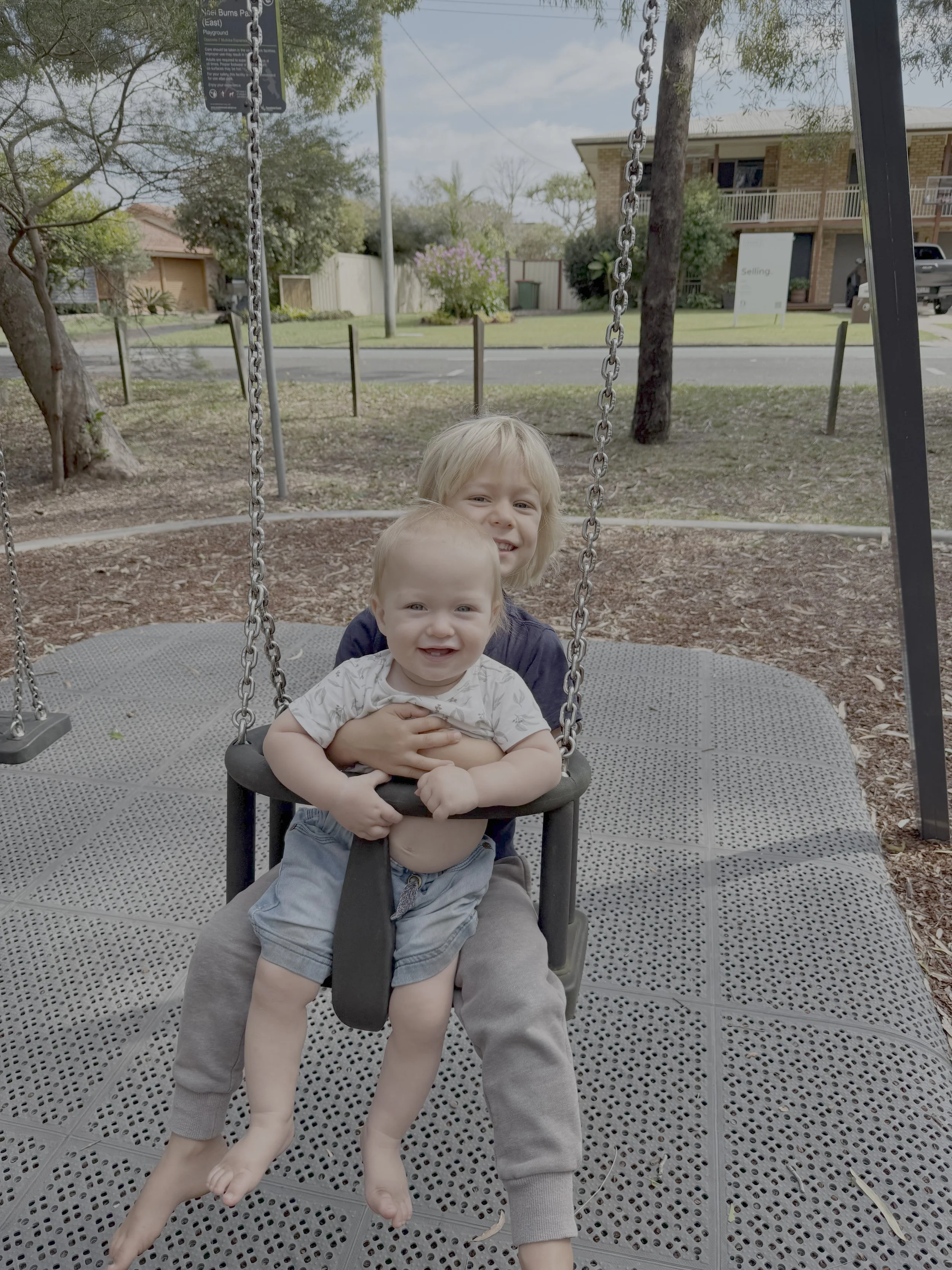 Children on a swing together at a local playground