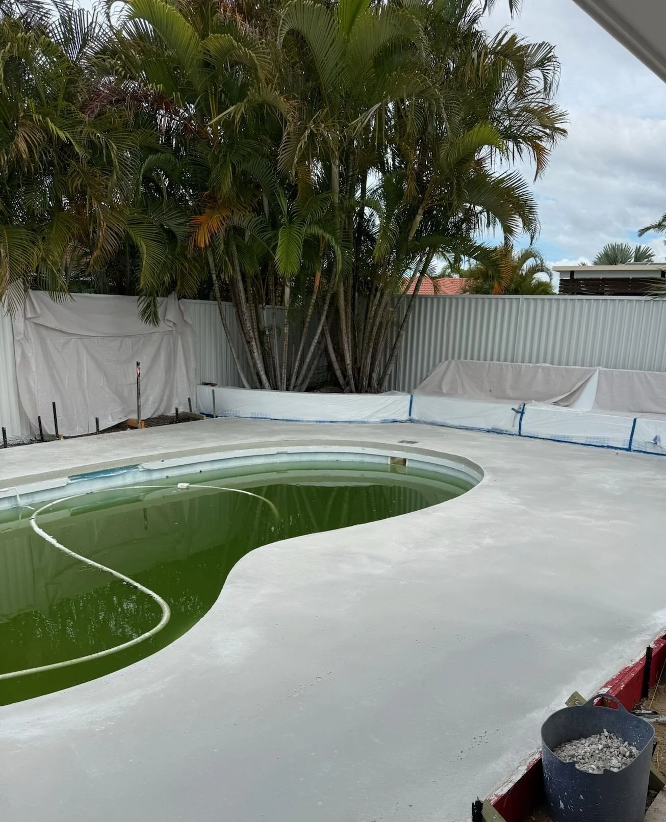 Poolside done right. We transformed this pool and surrounds with a finish that complements the landscaping and completes the space, all ready for honing. Swipe to see the before.