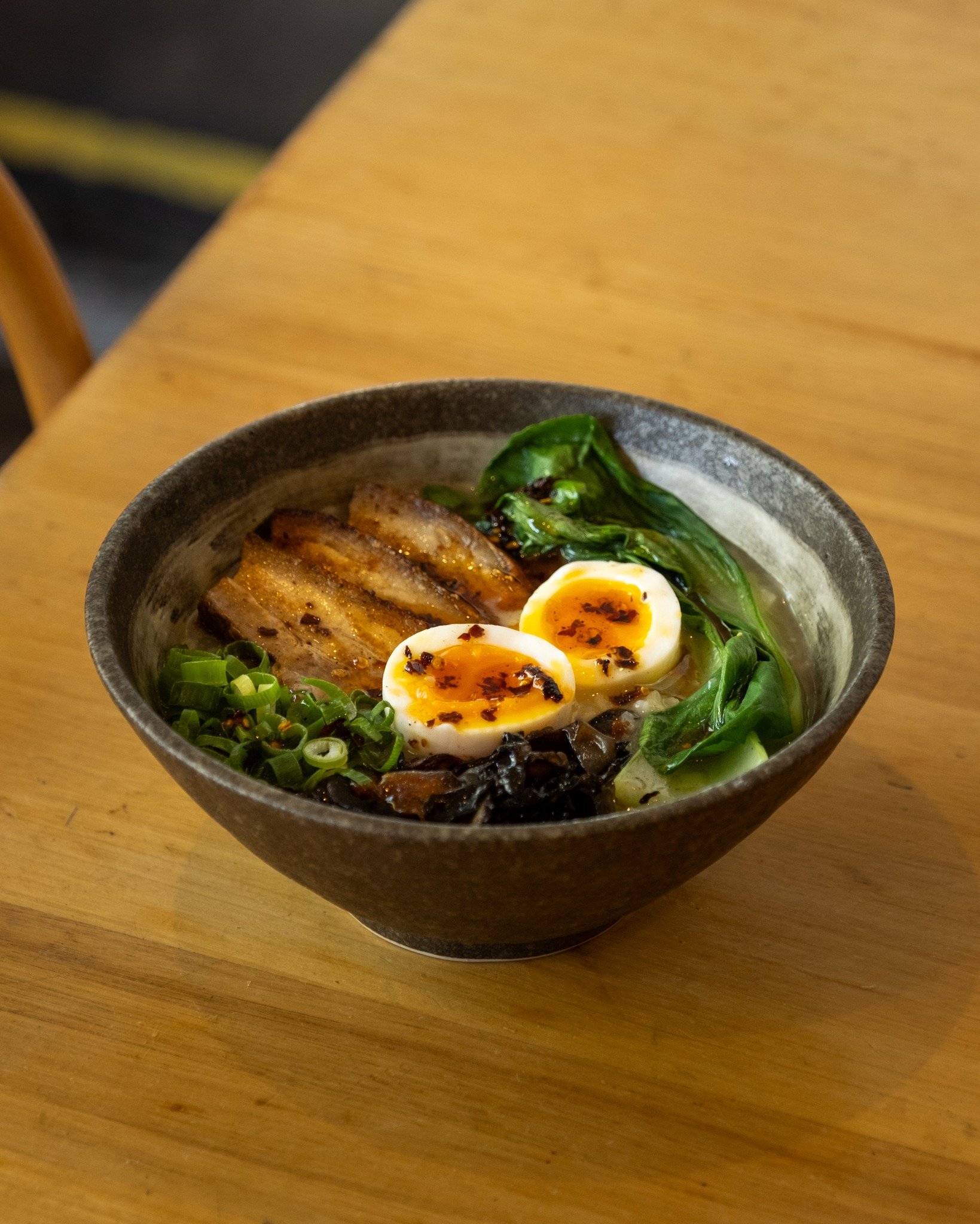 Warm up with a comforting bowl of lemongrass-ginger congee, pork belly, mushrooms, soft egg, gai lan, green onions, and a hint of chili oil&mdash;perfect for chilly days.