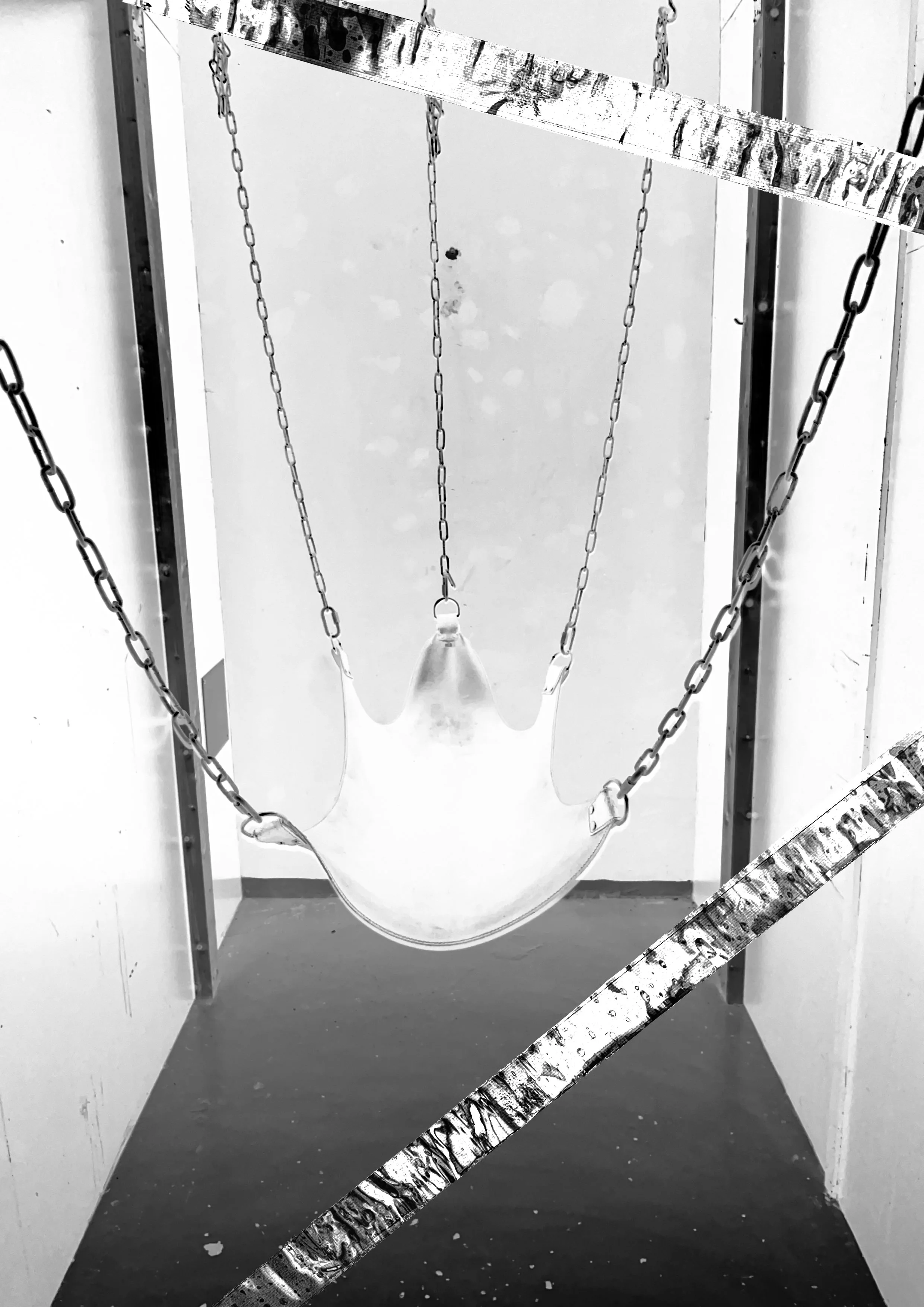 An art installation featuring a sculpted hand suspended by chains, with caution tape draped across the top and bottom of the frame.