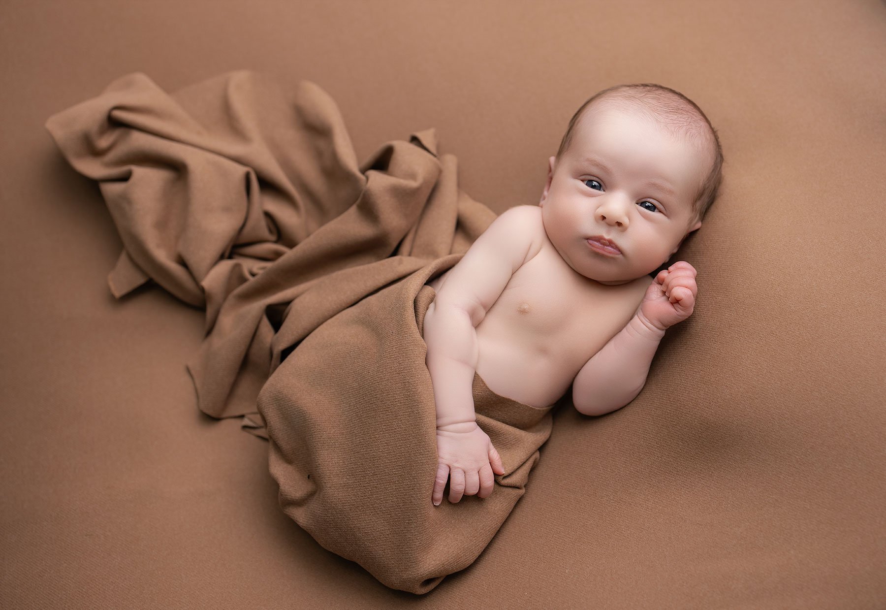 newborn baby looking at camera