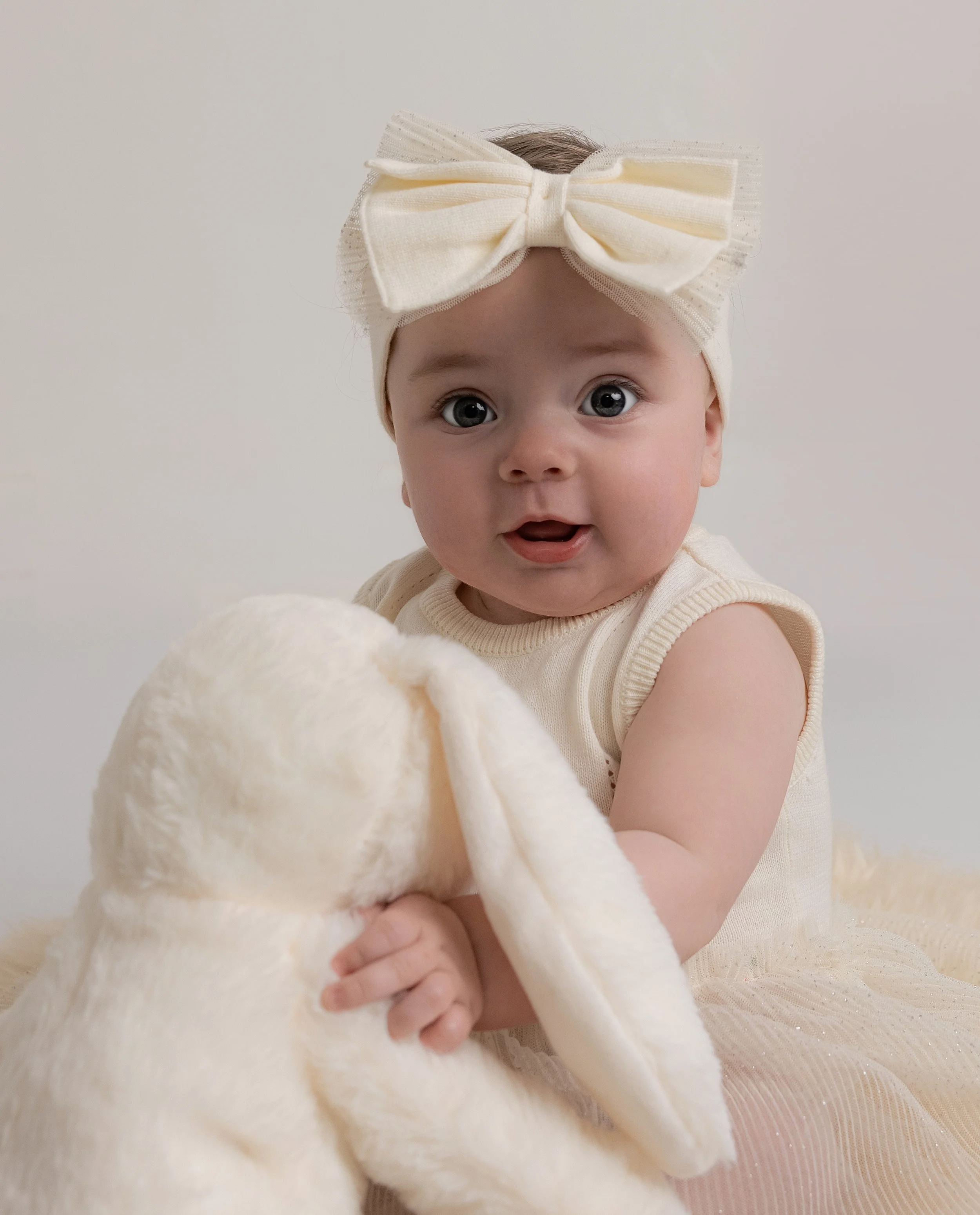 baby holding rabbit teddy