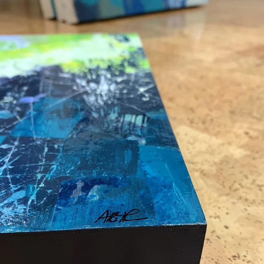 A close up of an artist signature on the bottom right corner of a painting