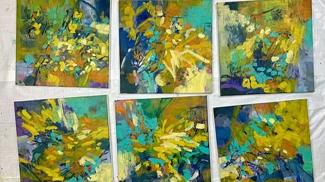 A series of six abstract paintings in progress, on the floor.