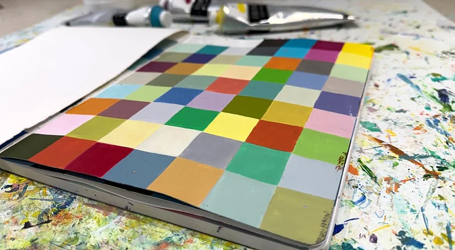 A sketchbook page filled with colourful squares in a grid.