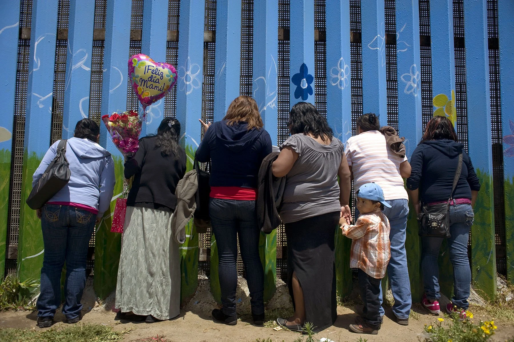  A woman, (second from left,) visits her daughter through the U.S.-Mexico border wall on Mother’s Day. They had not seen each other in 15 years. Tijuana, Mexico (2015)   