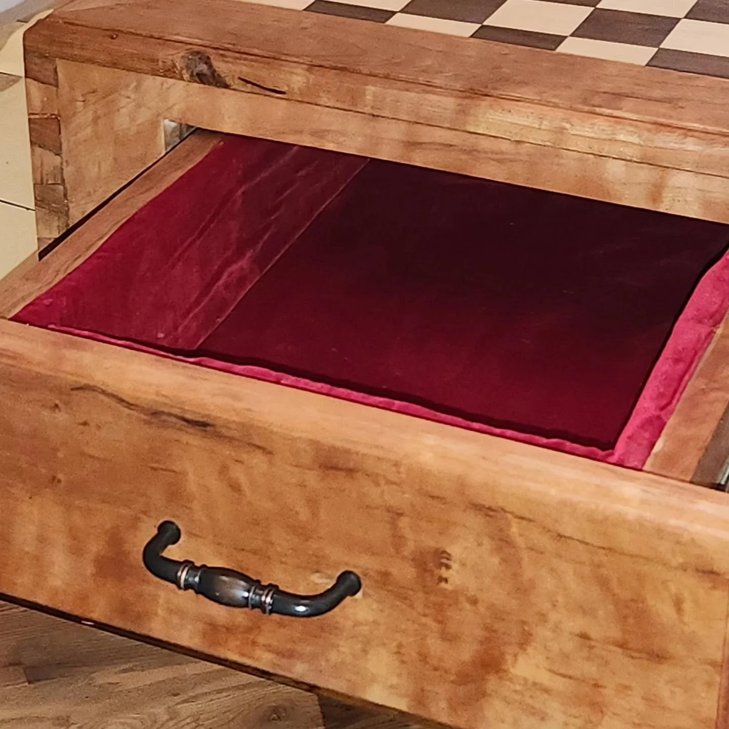 Chessboard with open drawer showing red velvet lining.