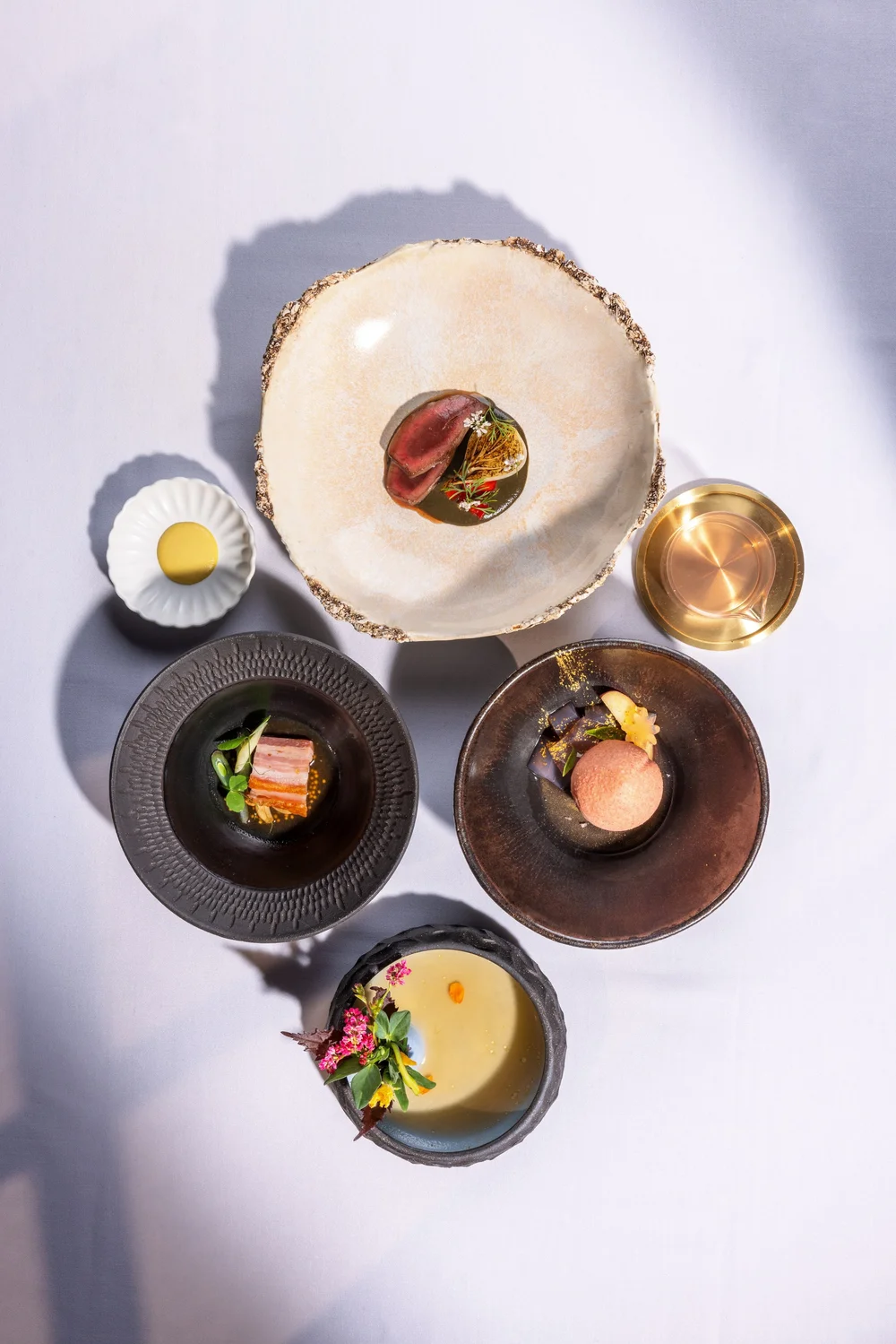 Nisei chef finishing a seasonal tasting menu course at the pass