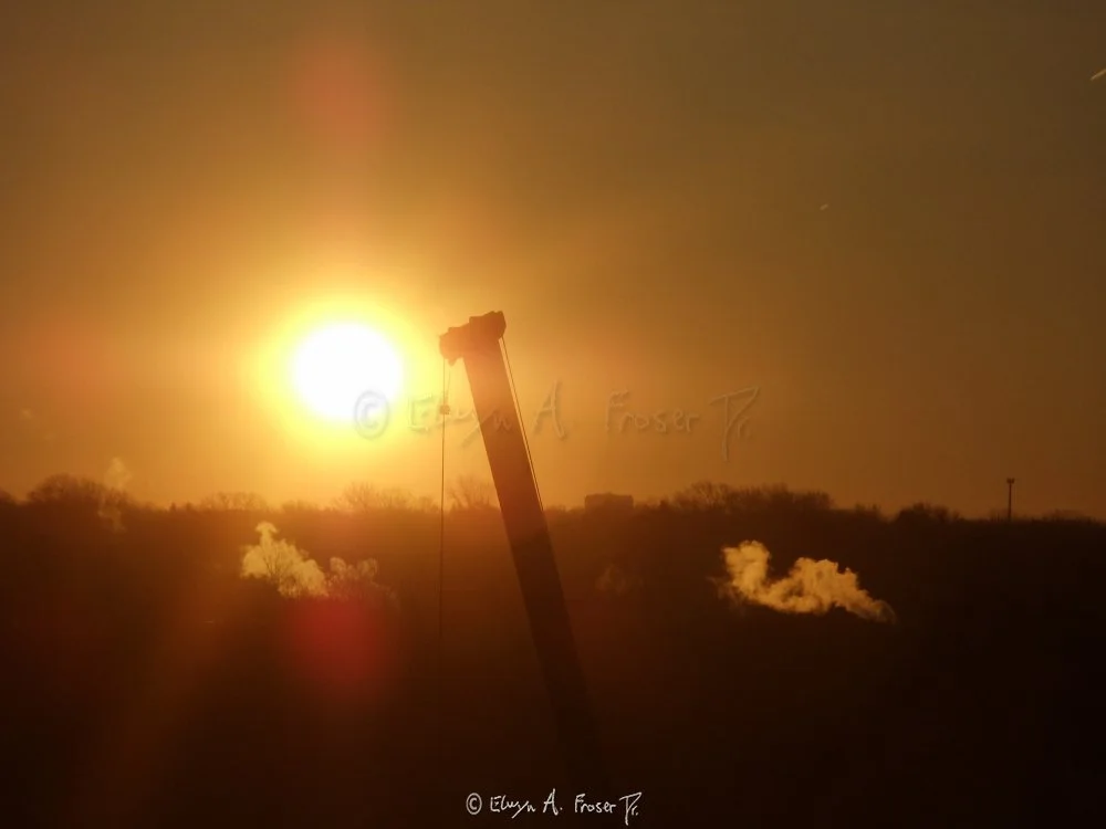 View 346 - silhouetted crane lift between to rising steam clouds glowing orange in beaming sunrise, Humanity, Minnesota USA, Winter 2014/2015