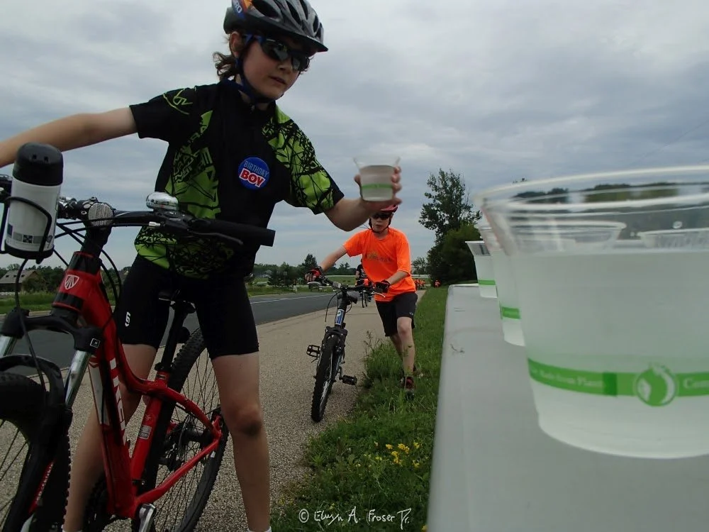 View 494 - birthday boy Bike Konnect participant reaching for water, Humanity, Carver County Minnesota USA, Summer 2016