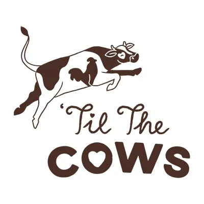 A cartoon cow with a bow on its head and a happy expression, jumping over the text 'Til The Cows' in stylized font.