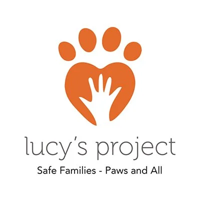 Logo for Lucy's Project featuring a paw print and a hand inside a heart, with the slogan "Safe Families - Paws and All."