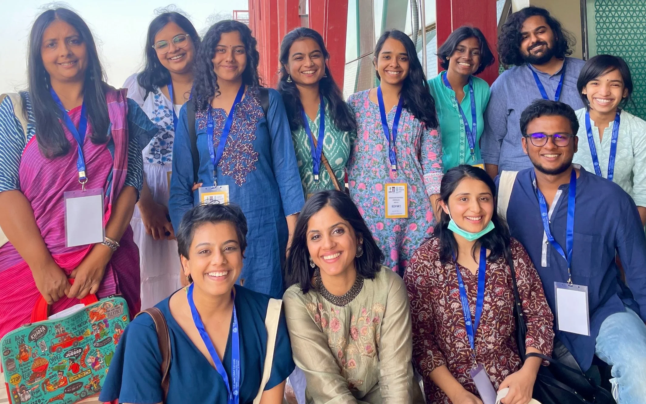 A group of persons posing for a picture in a college campus, all with bright smile