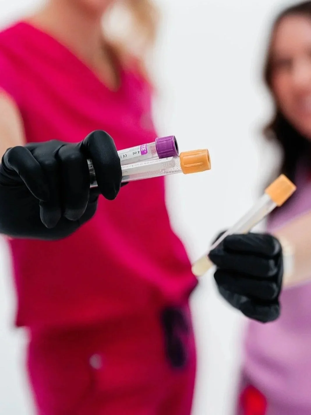A Younger You Aesthetics nurse practitioners showcasing injectable vials used for botox or other beauty fillers and injectables while smiling warmly