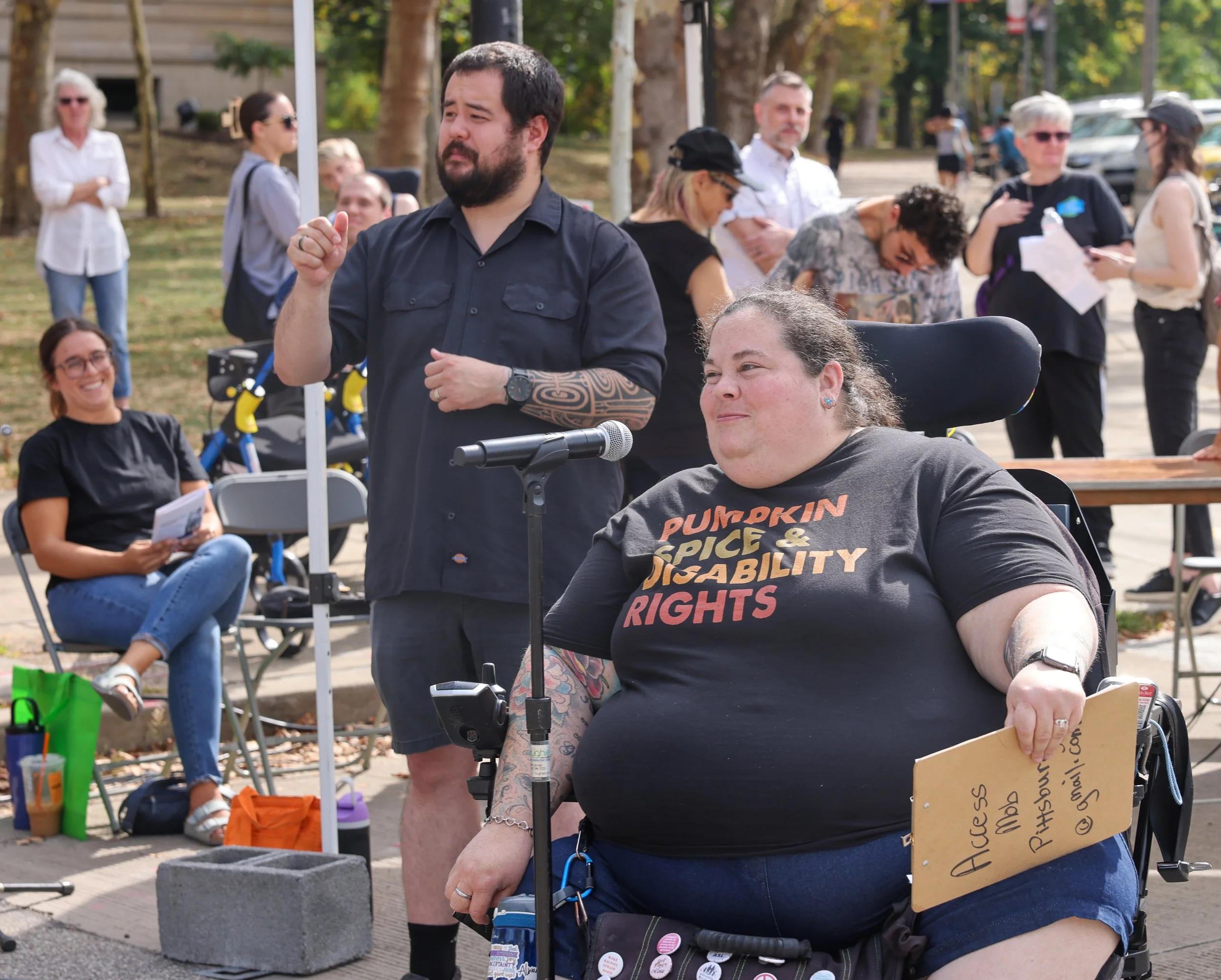 Power chair user wearing "Pumpkin Spice and Disability Rights" shirt