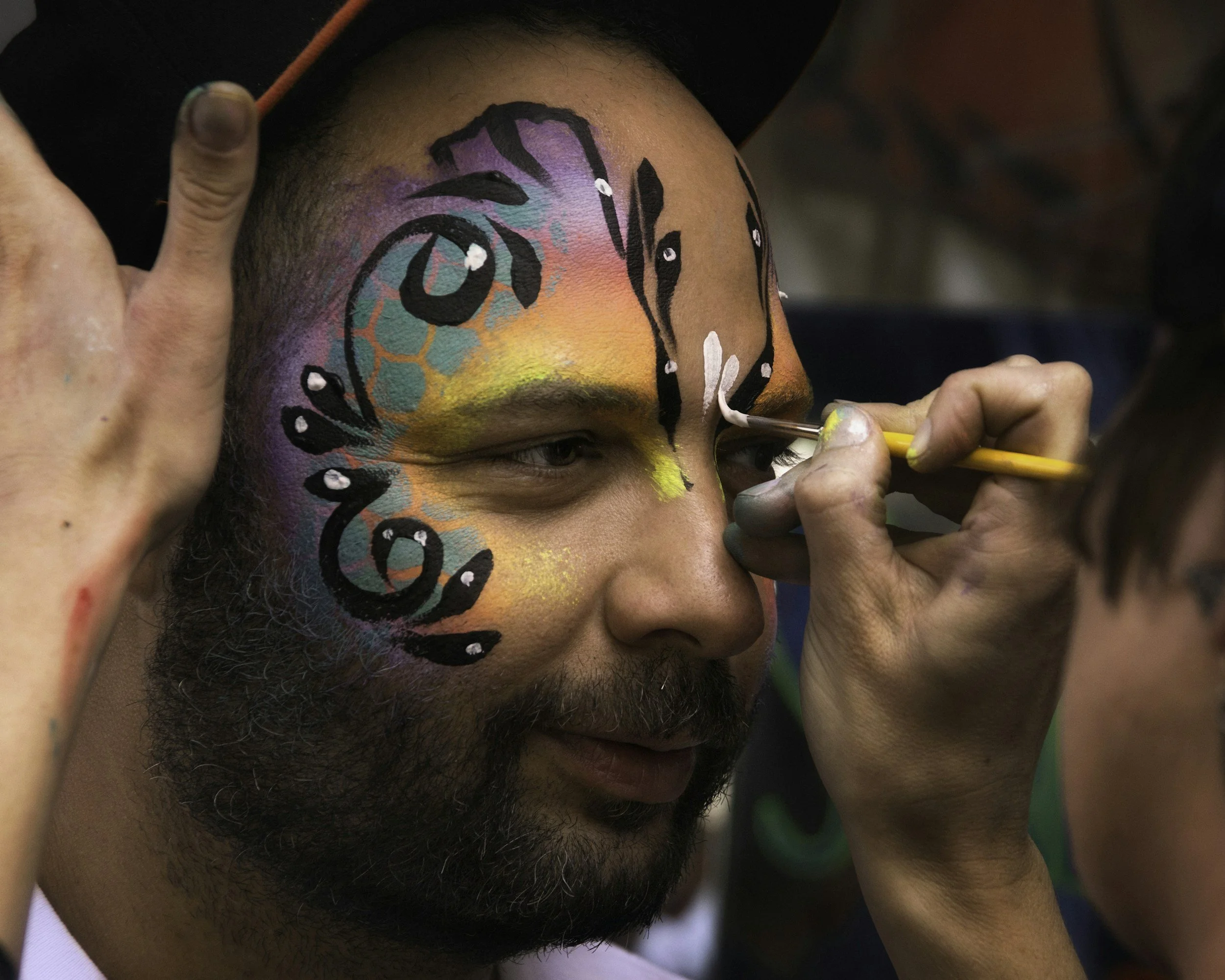 A man getting his face painted.