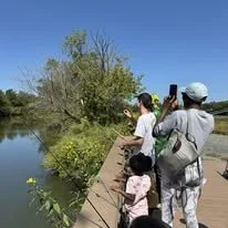 A group of people of all ages fishing off the dock