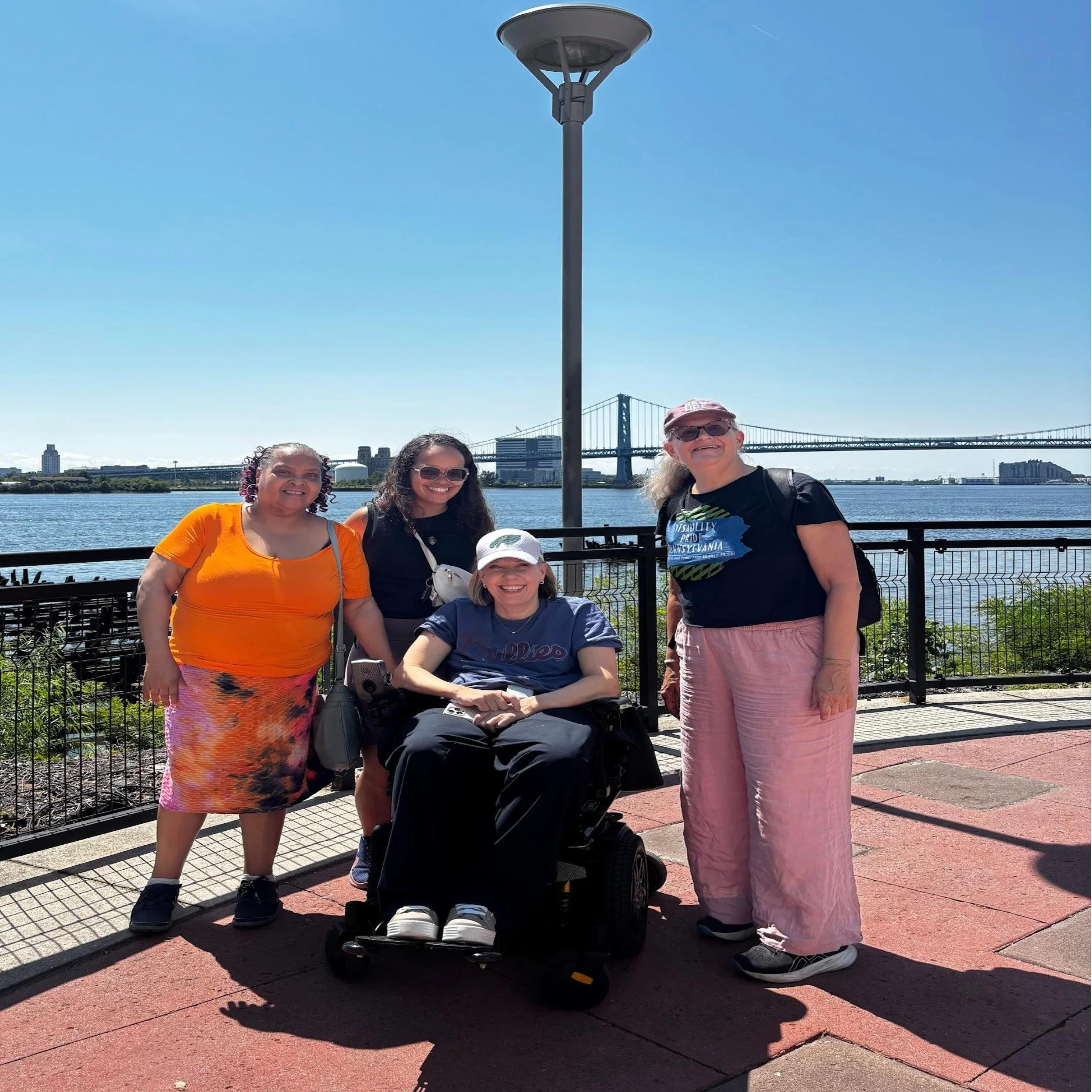 A group of people together with the river and bridge behind them on the Delaware River Trail.