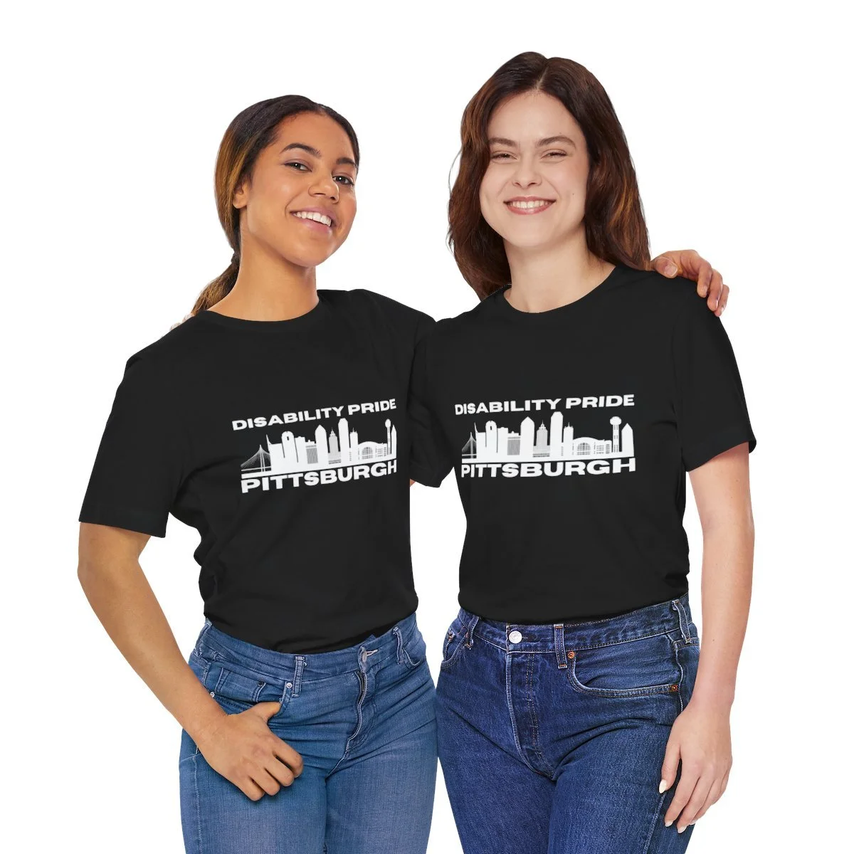 Two people with arms around shoulder in black tees with Disability Pride Pittsburgh logo