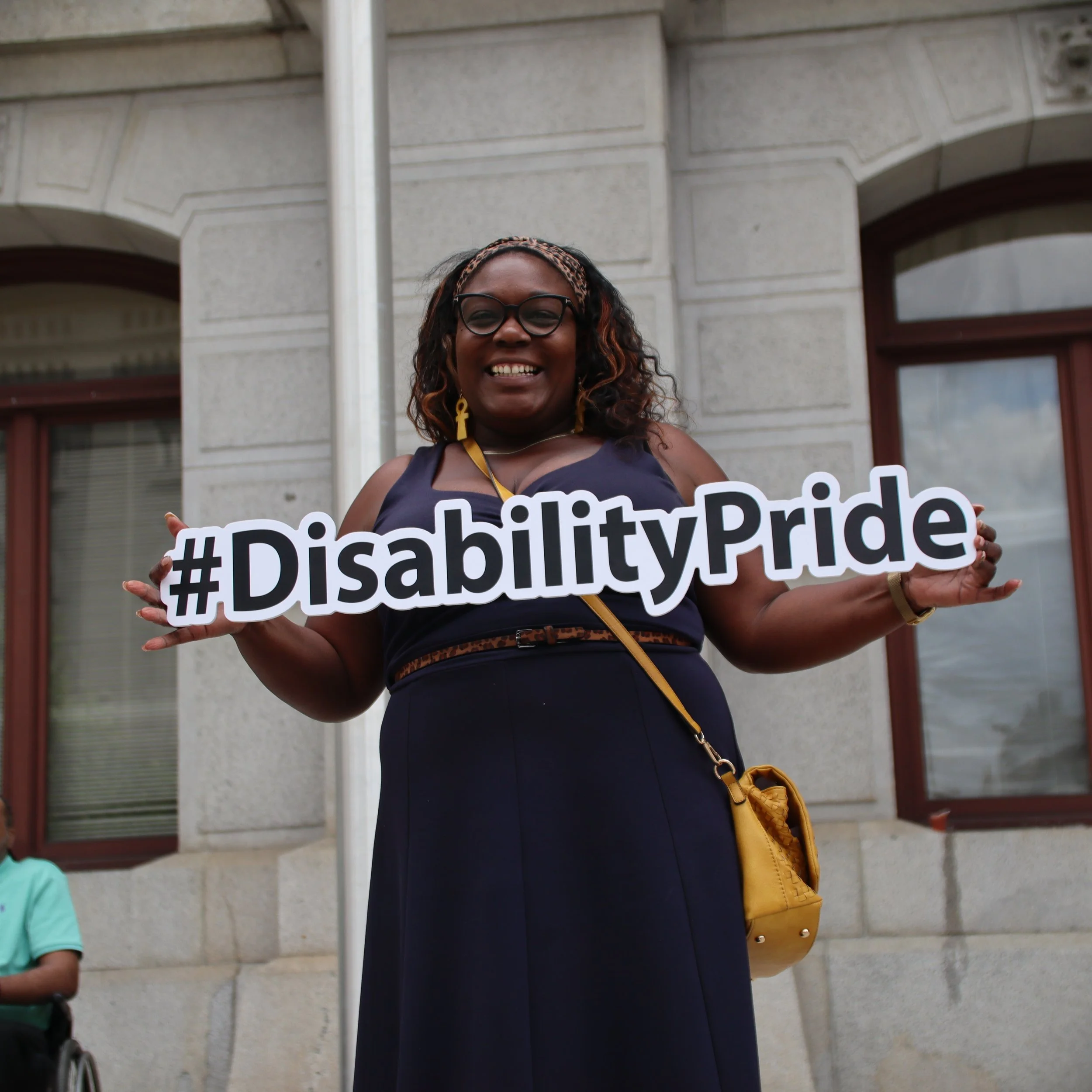 Councilmember Kendra Brooks holding #DisabilityPride sign at City Hall