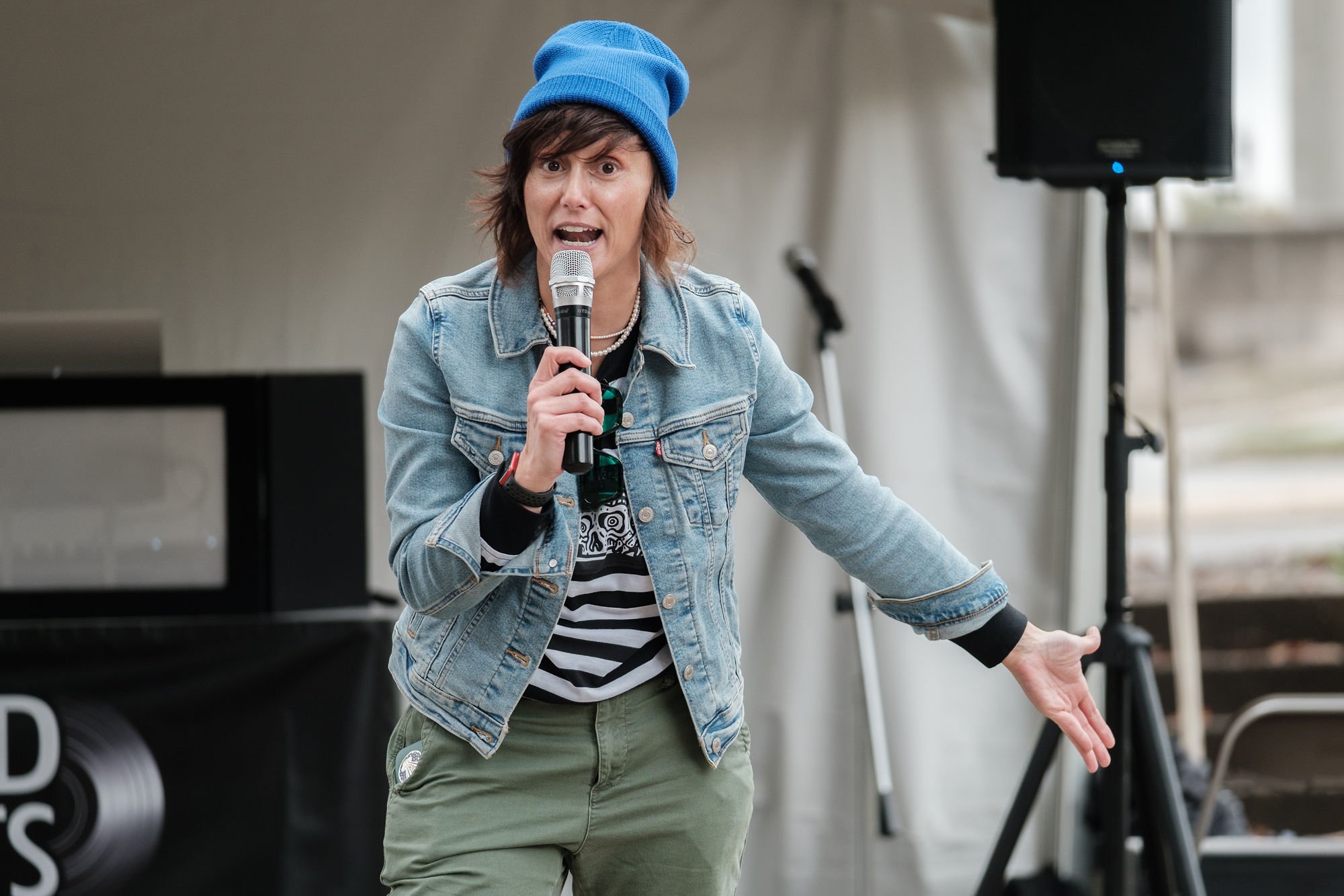 Gab Bonesso with blue beanie and jean jacket performing at Disability Pride Central PA