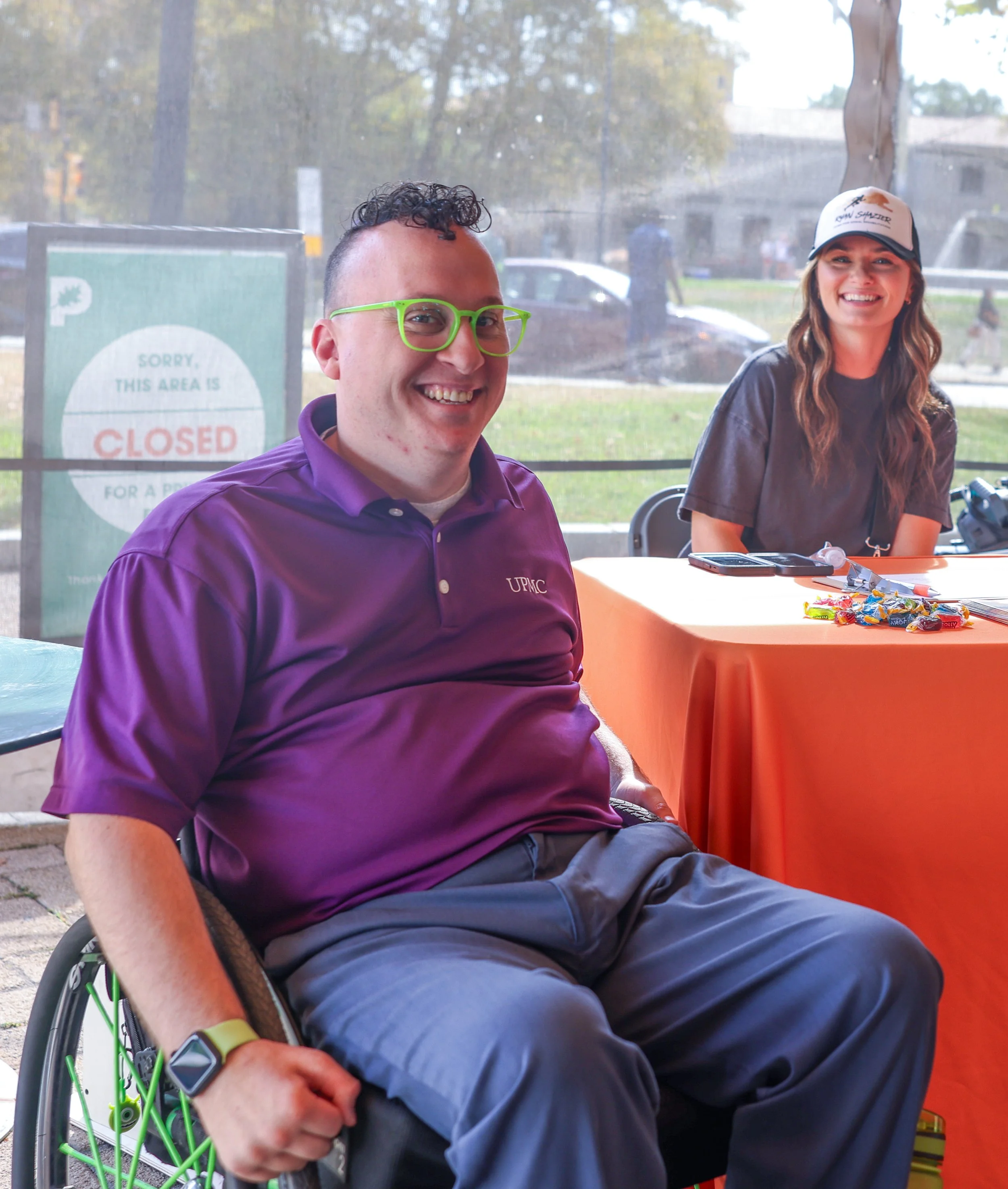 Board member and wheelchair user Matt Berwick wearing bright purple shirt and green glasses