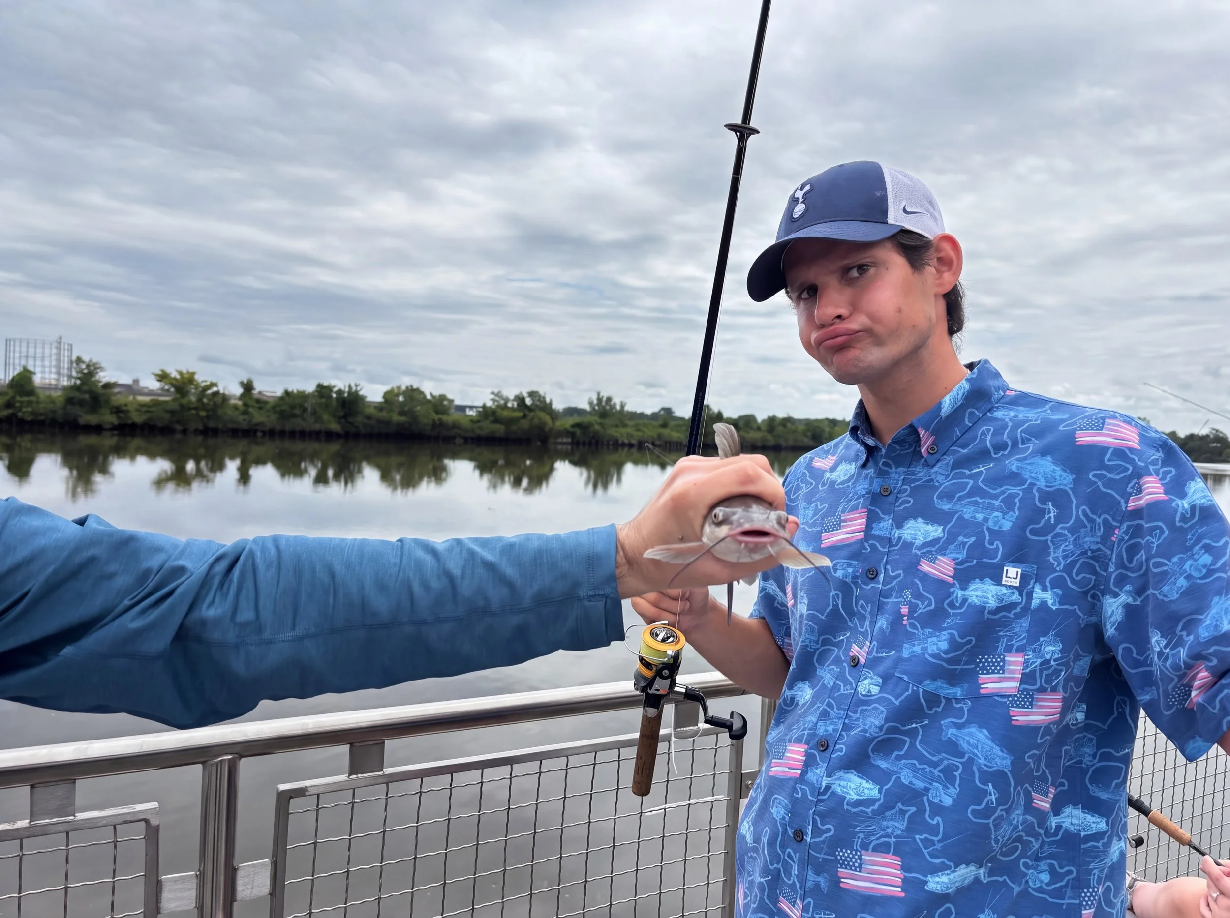 A person making a fish face while another person holds the fish up