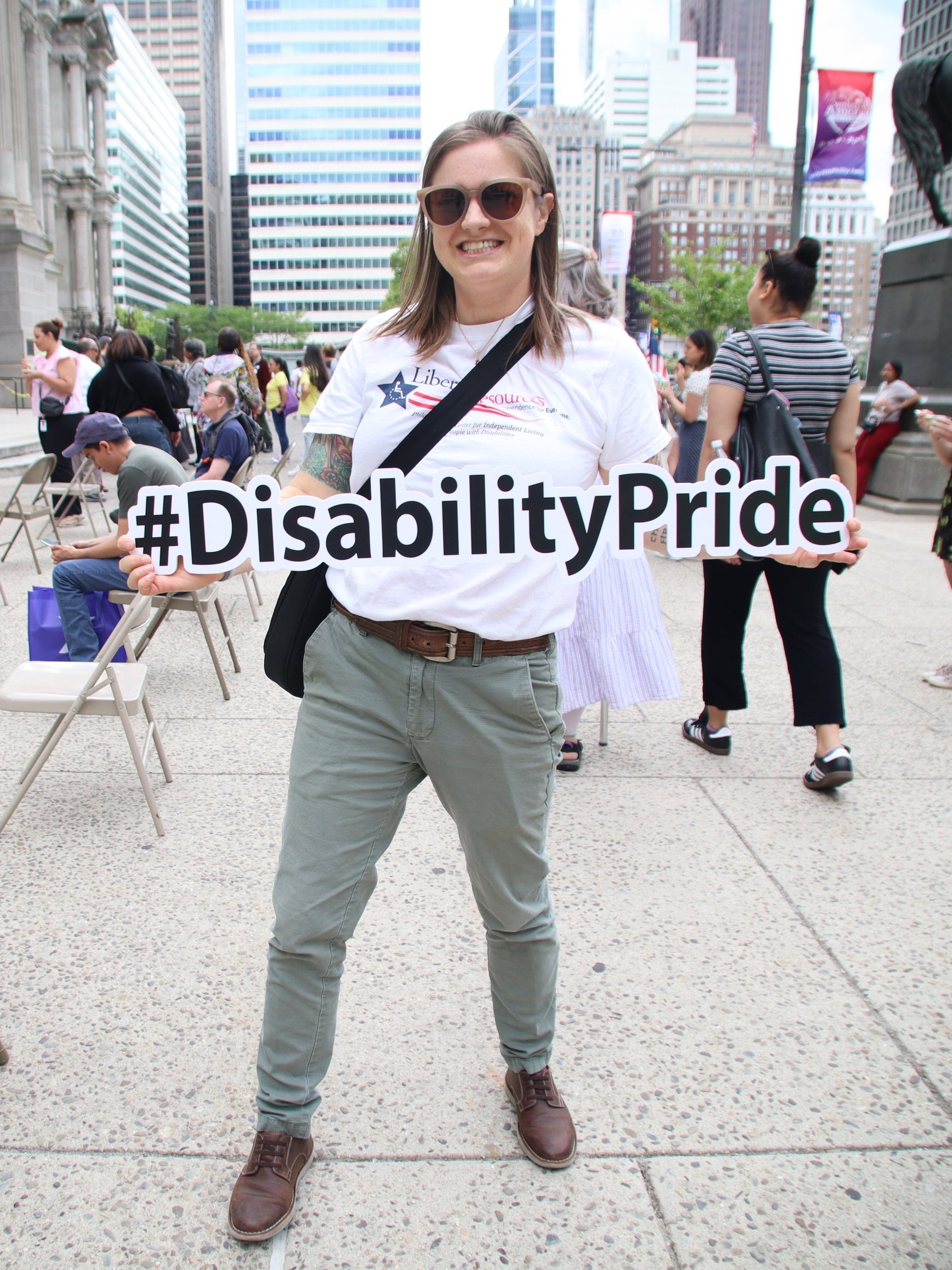 A person is holding a white cutout with #DisabilityPride