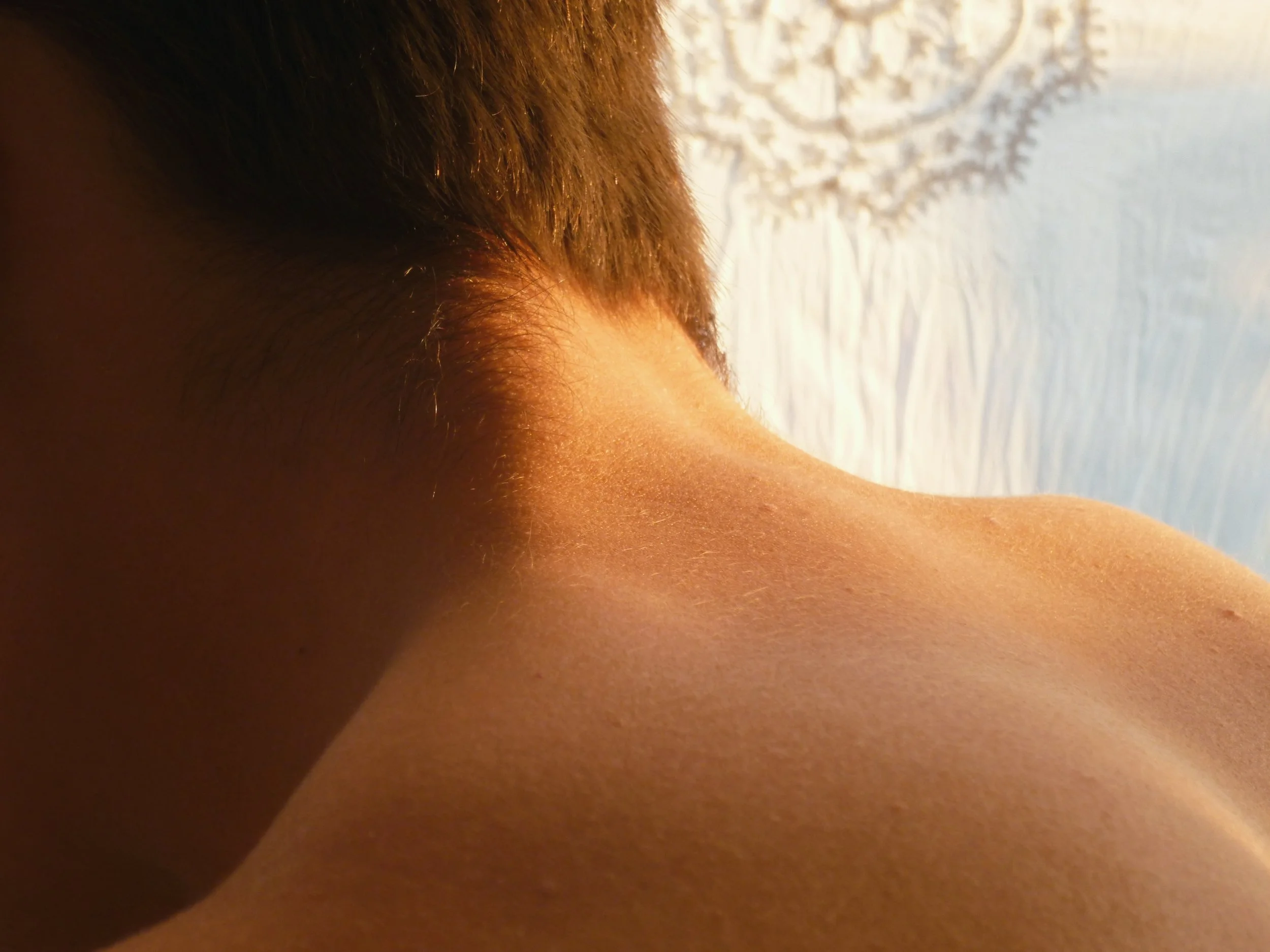 The setting sunlight bounces off the back of a young man on the coast of Stara Novalja.