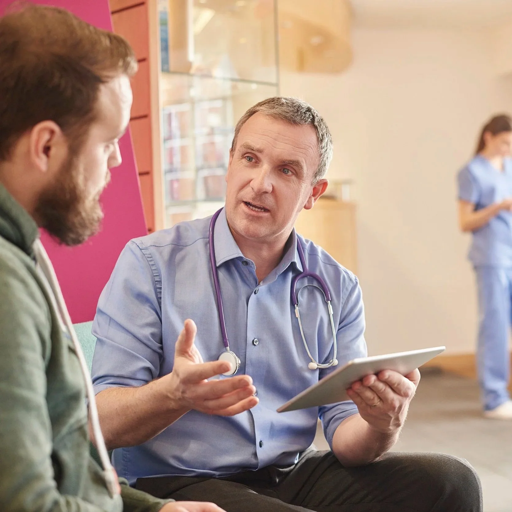A doctor explains data from a clipboard to a member