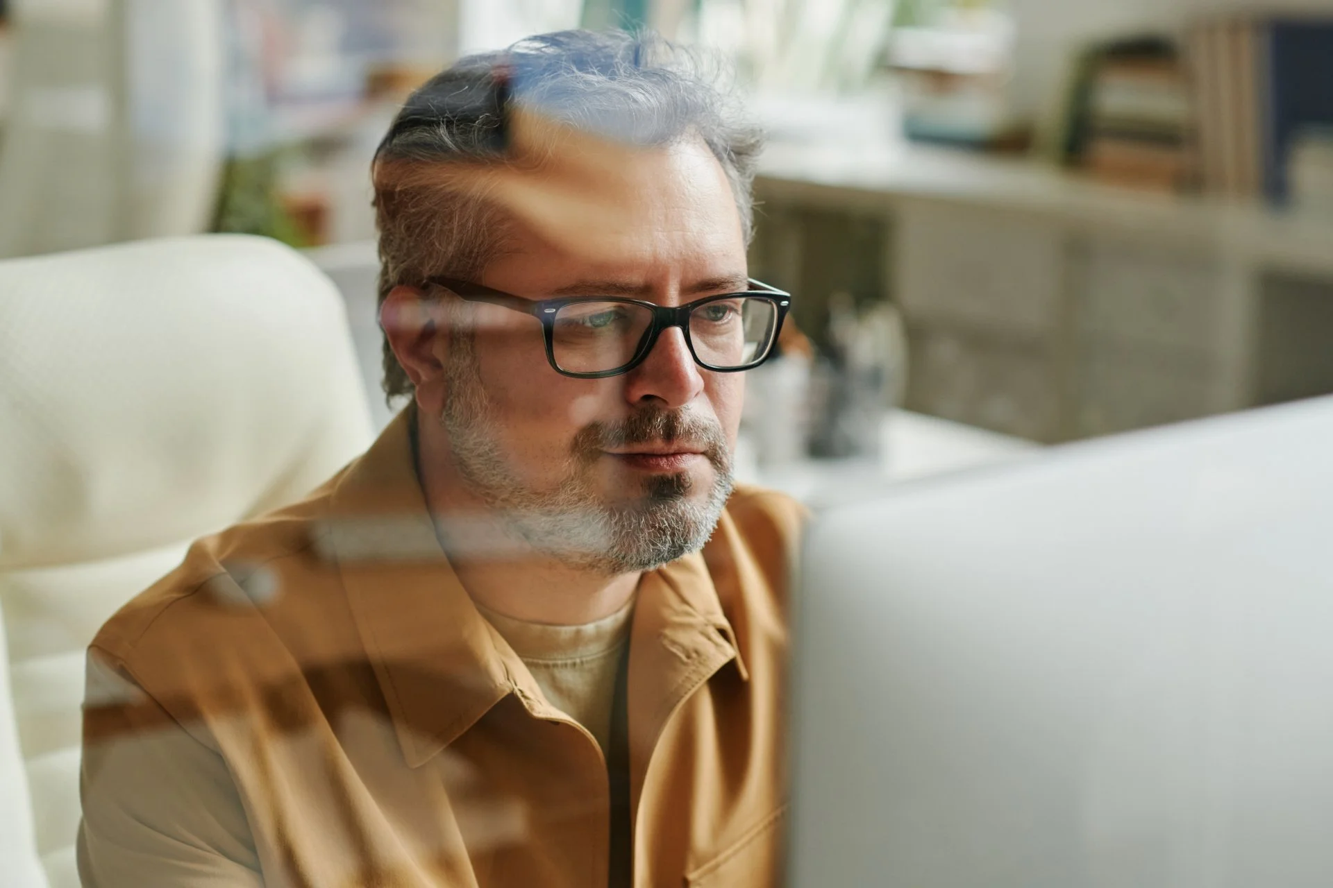 A man looks at a computer screen. $2 million sounds like enough—but healthcare, long-term care, and Social Security timing change everything. See the real case study and numbers.