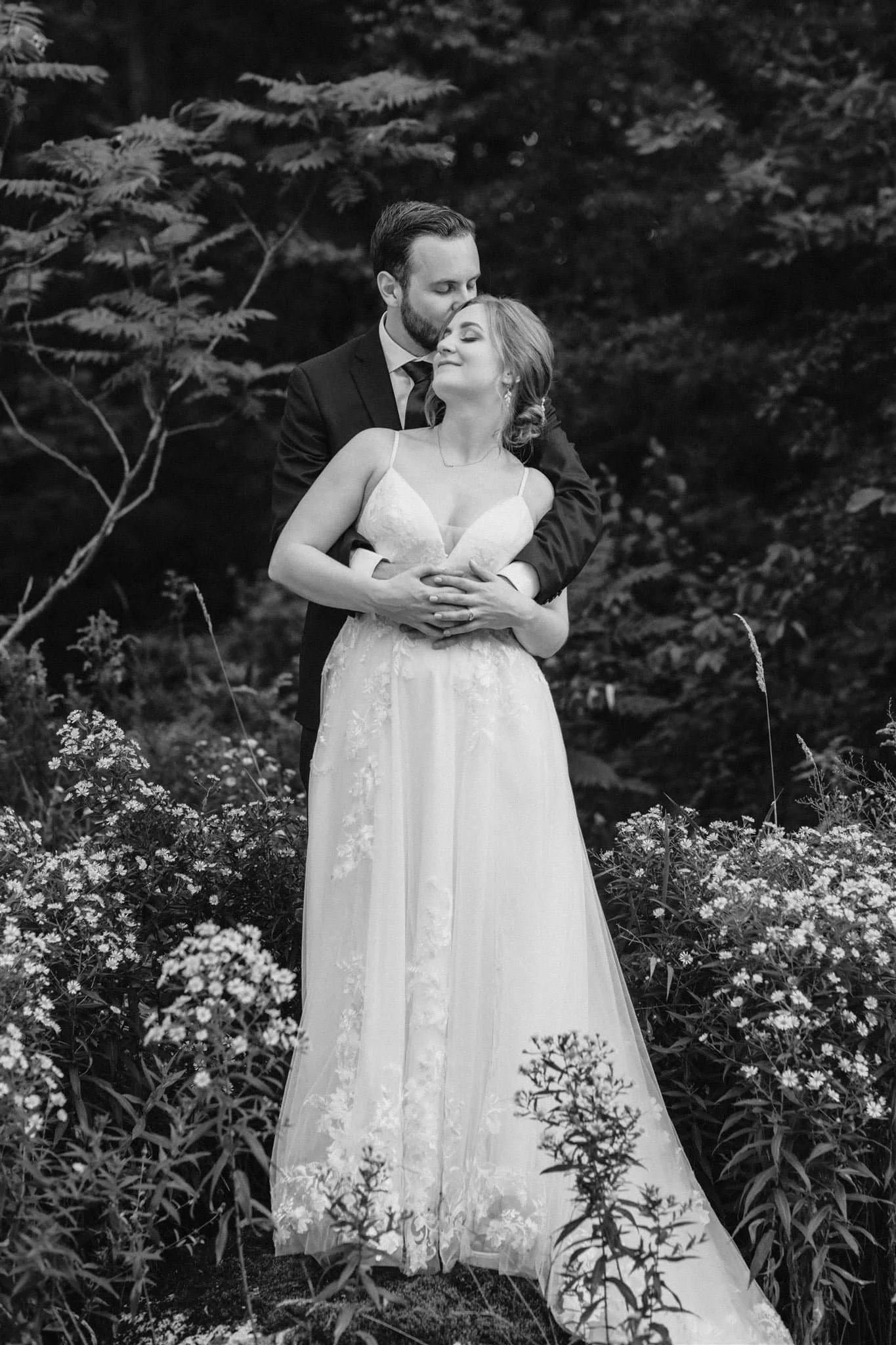 Black and white portrait of groom holding bride at Serenity Cottage wedding